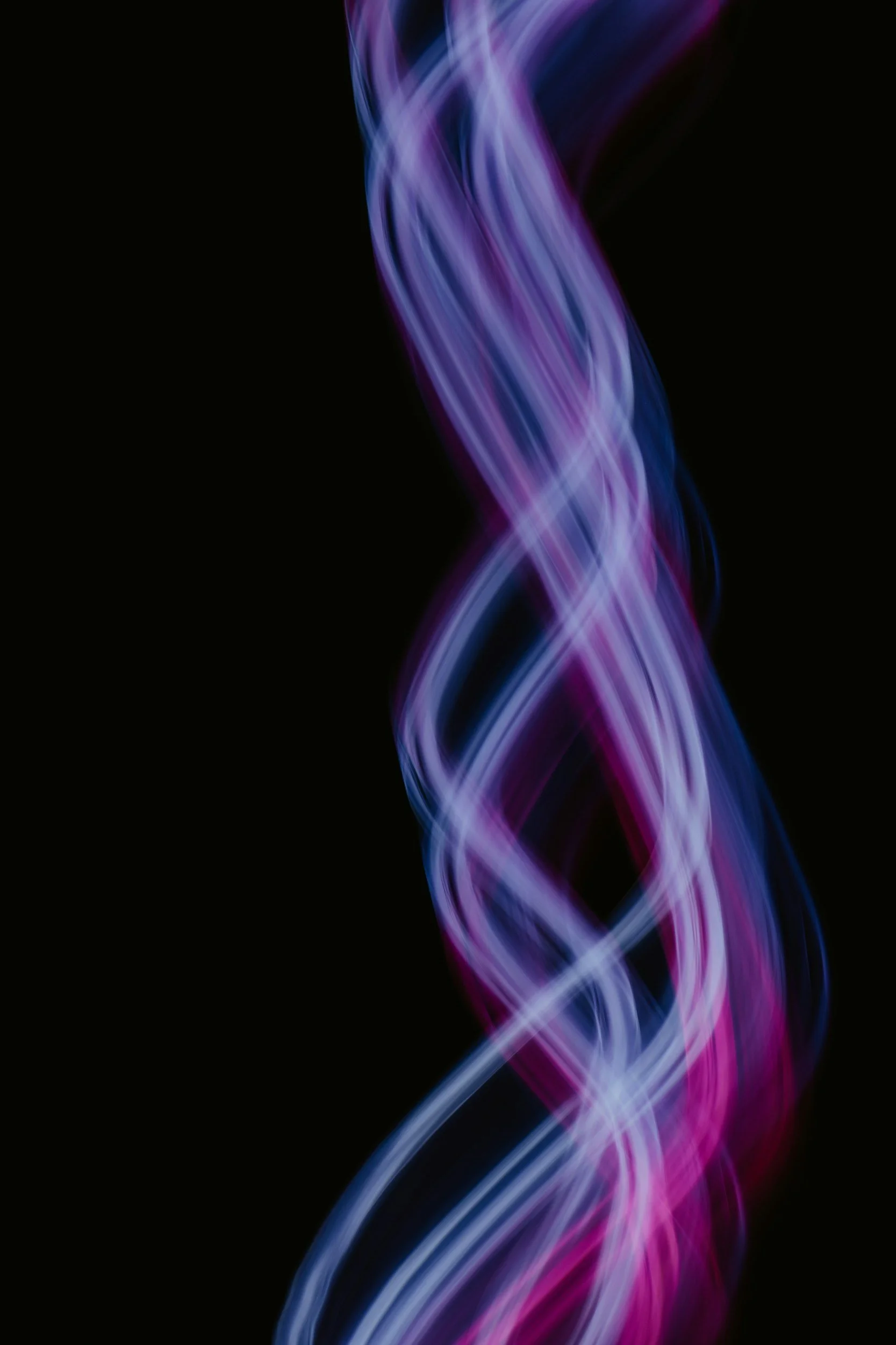 Colorful light streaks in purple, pink, and blue against a black background.