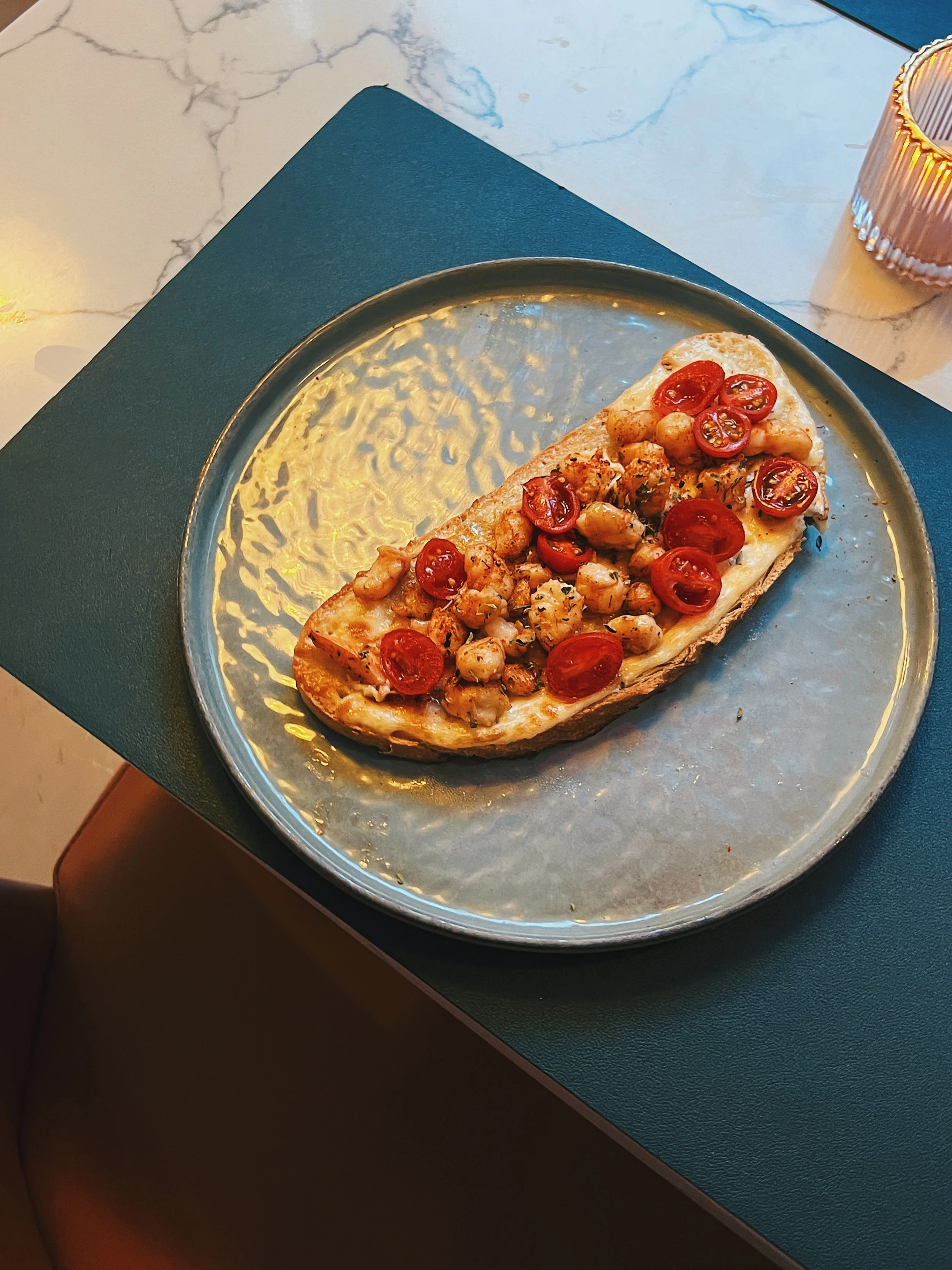Crispy flatbread with cherry tomatoes and toppings served at Mokelino tapas restaurant.