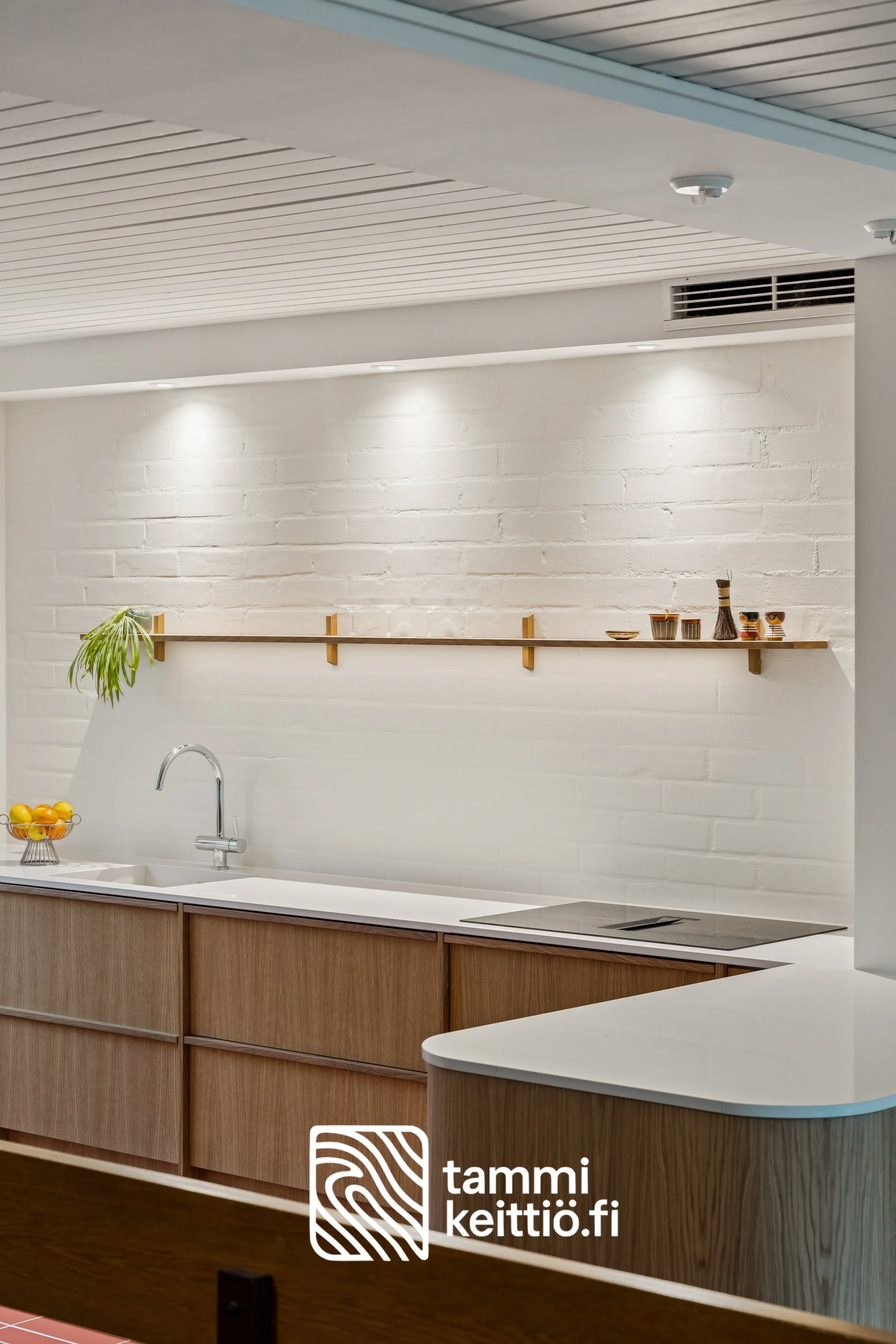 Avohylly pyöristetyssä tammikeittiössä tiiliseinämällä