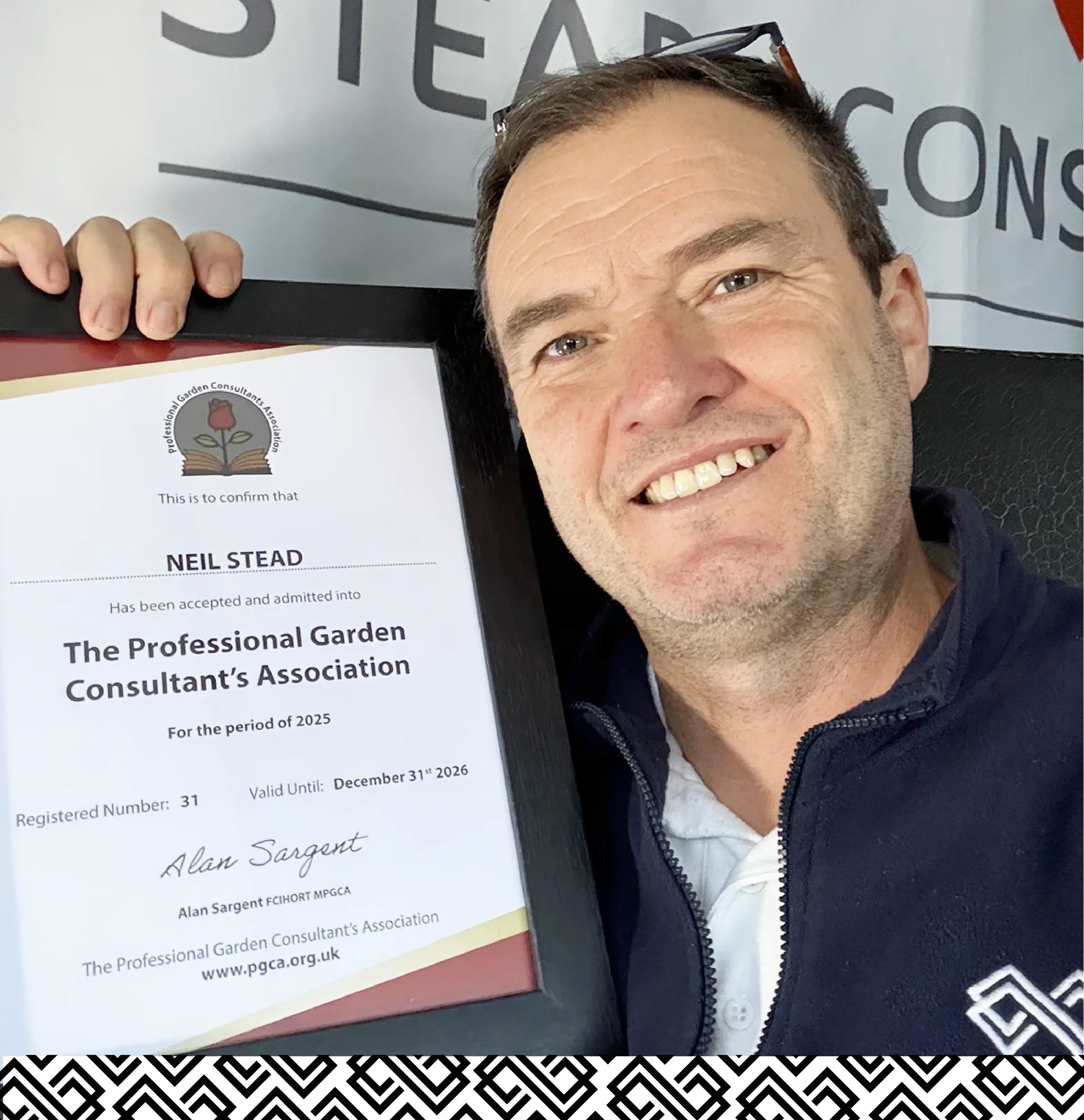 Neil Stead, business consultant for landscapers and the horticulture industry is holding up his framed certificate from The Professional Garden Consultant's Association