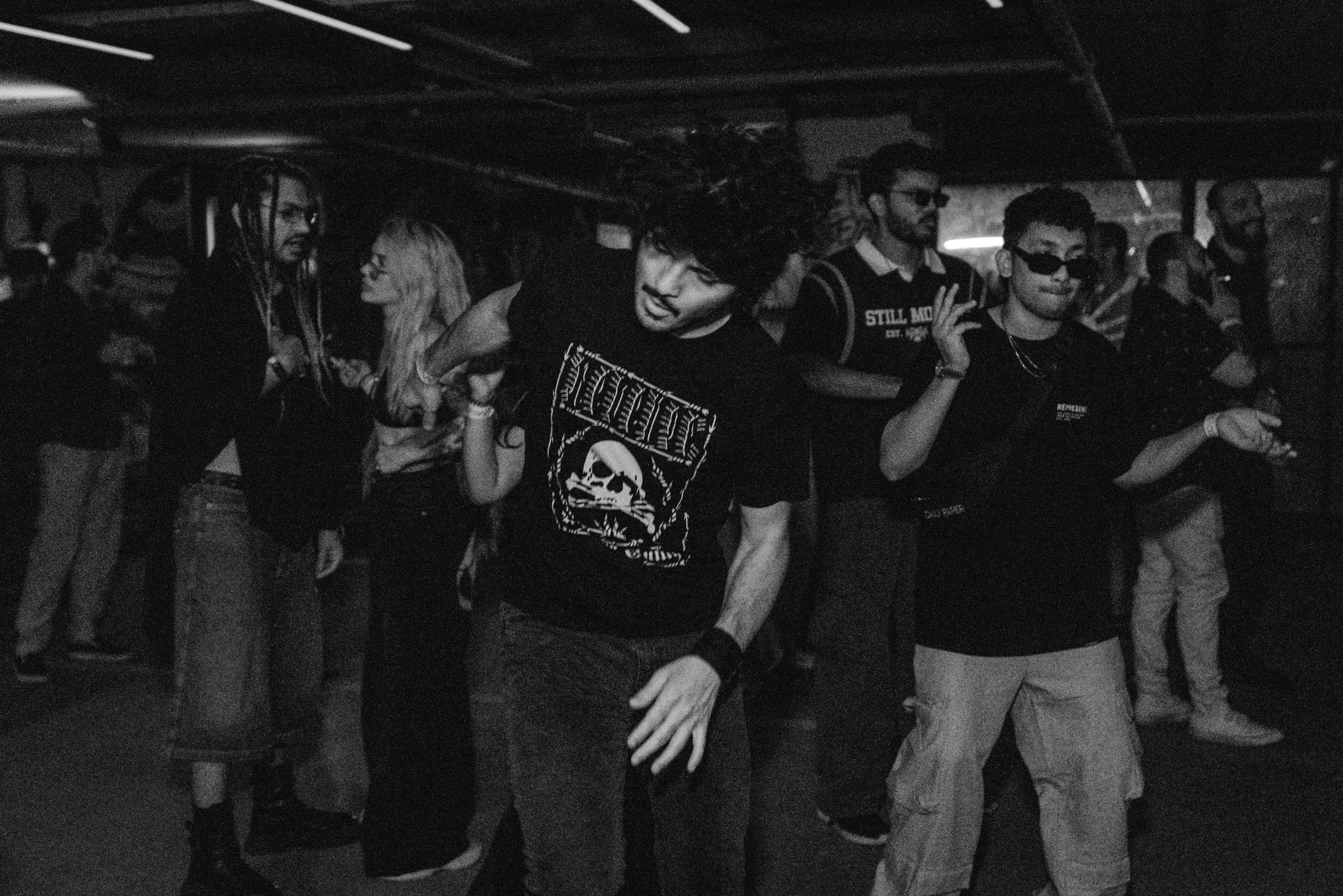 People dancing and socializing at a party or nightclub in black and white.