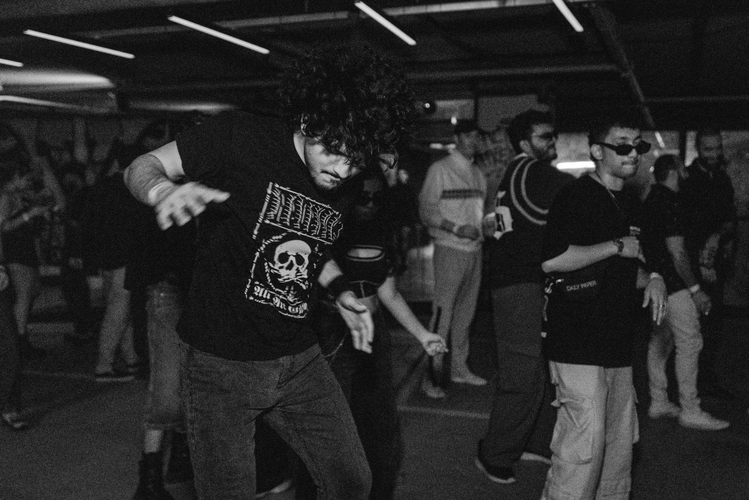 People dancing and enjoying themselves at a dark indoor event or nightclub.