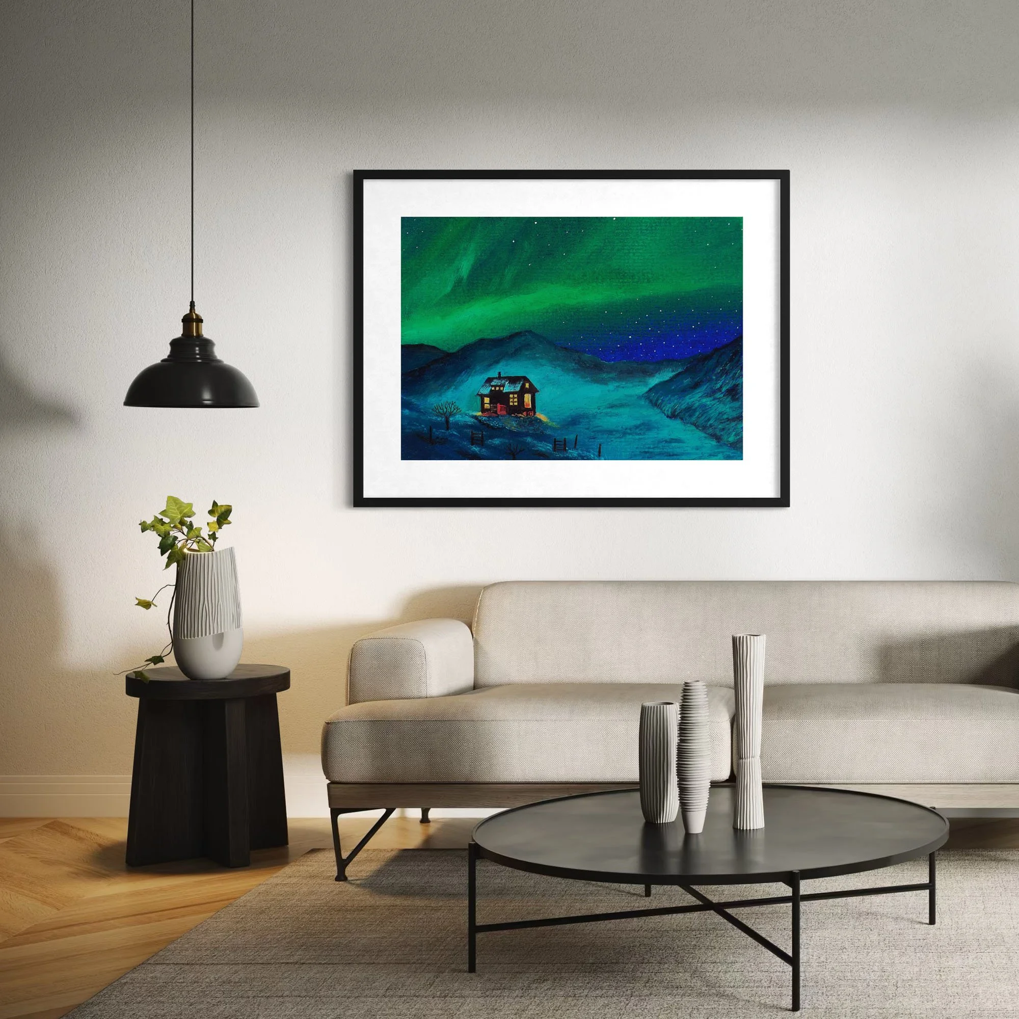 Contemporary living room with two round coffee tables, a wall-mounted painting of a landscape with mountains and aurora borealis, a beige sofa, a tall white vase with green ivy, a black side table, black and white vases, and a hanging black pendant light.