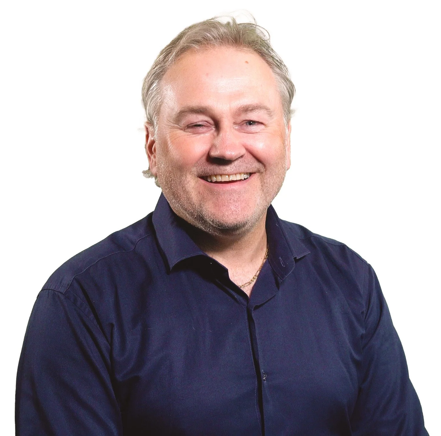 Smiling middle-aged man with light hair, wearing a dark blue shirt, against a plain white background.