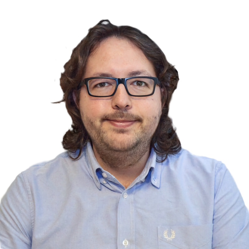 A person with long hair and glasses wearing a light blue collared shirt.