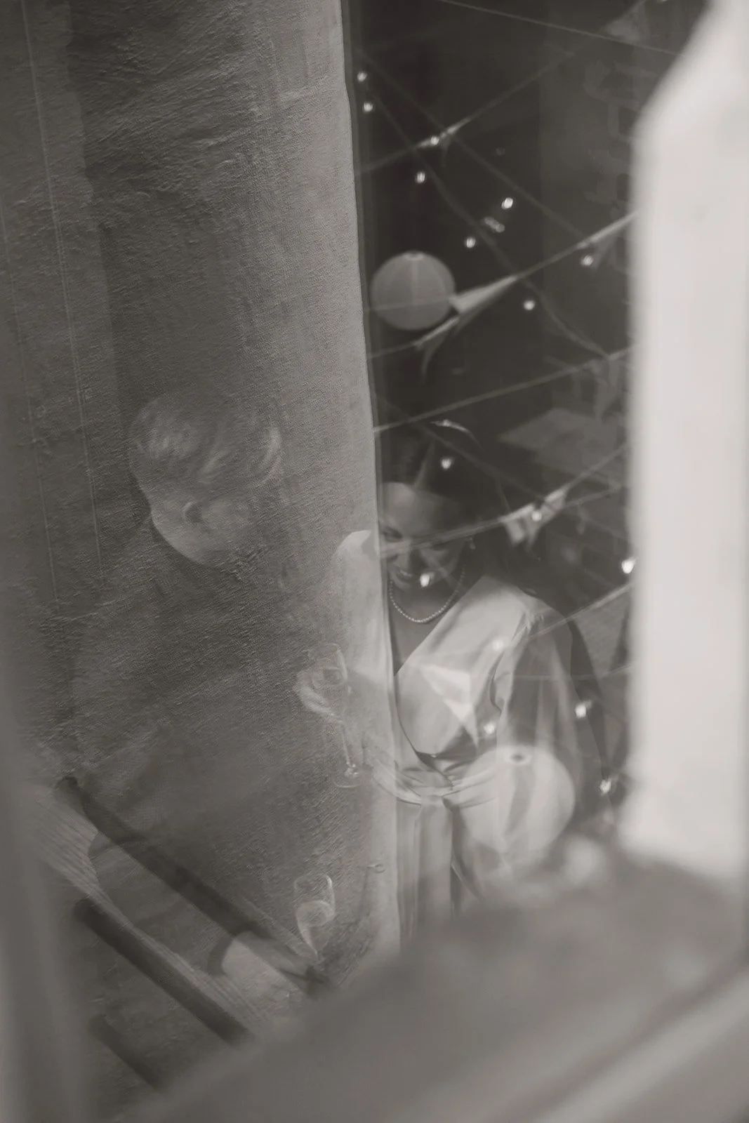 To personer ser gjennom en glassvegg som er dekket av dryppende vann»