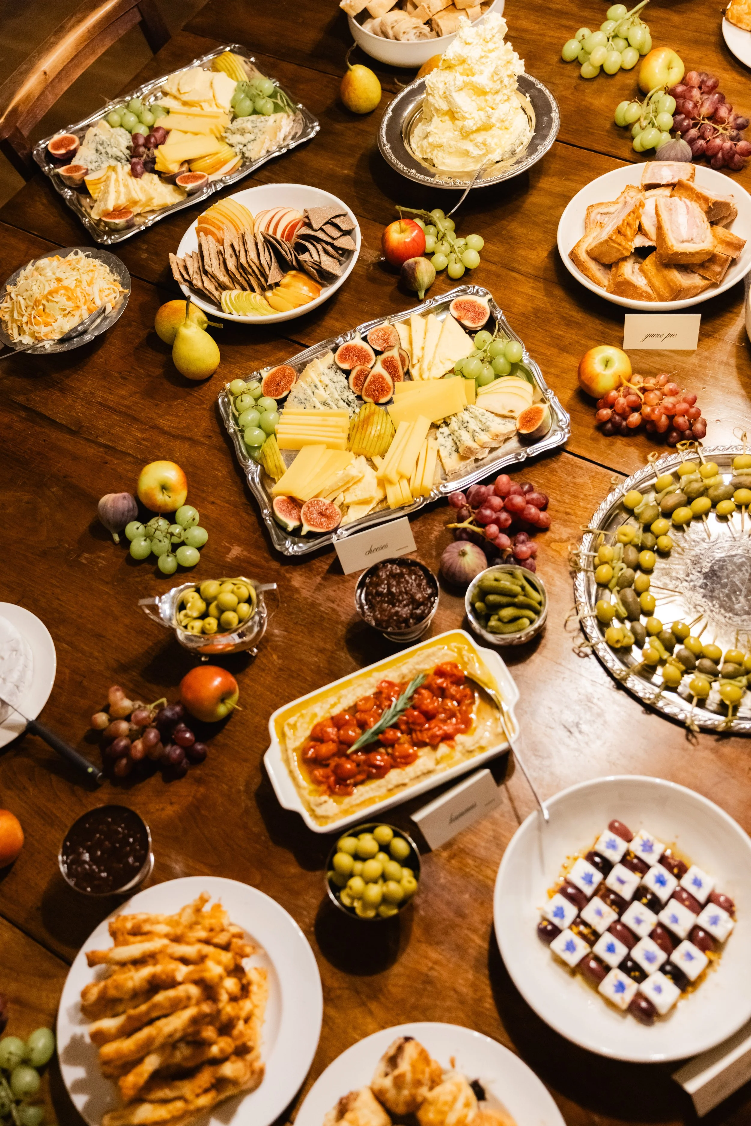 Ulike oster, frukt, kaker og snacks på et dekketbord.