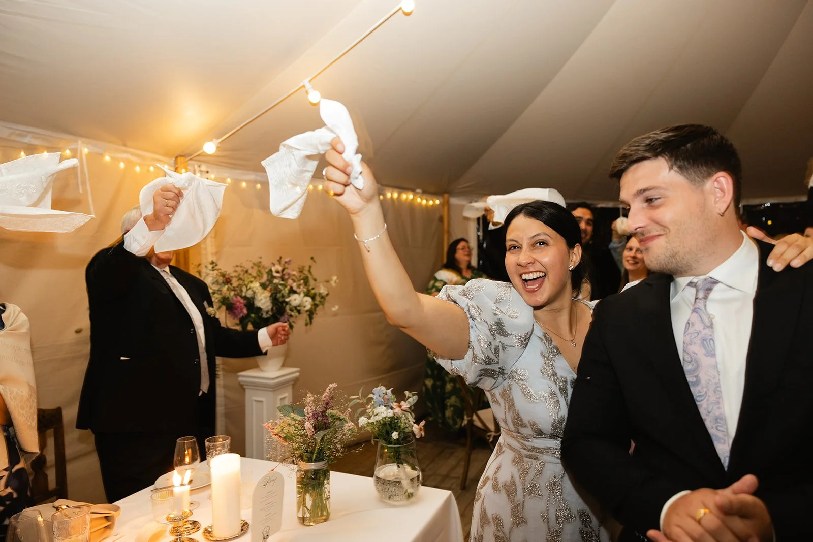 Et ektepar deltar i en tradisjonell bruddprøvingsaktivitet med å kaste oppklipte lommetørklær under en brullupsfeiring.