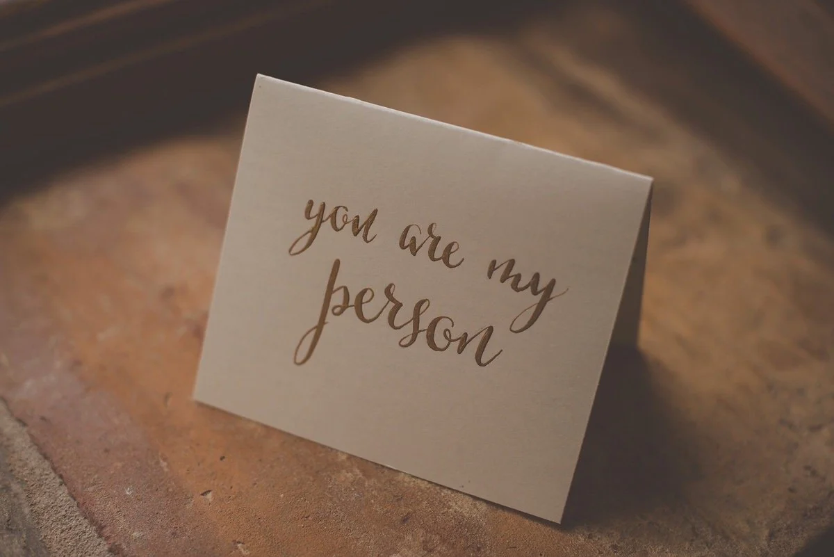 A beige card with the handwritten message 'you are my person' on a textured surface.