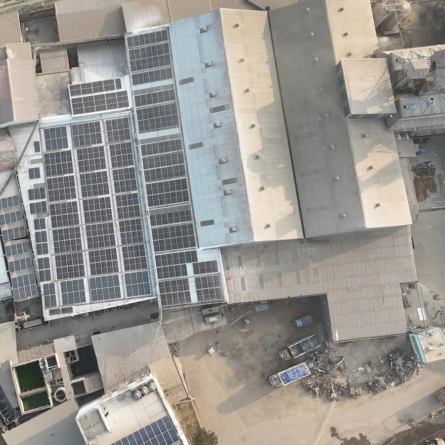 Aerial view of rooftops with solar panels on several buildings in an industrial or commercial area.