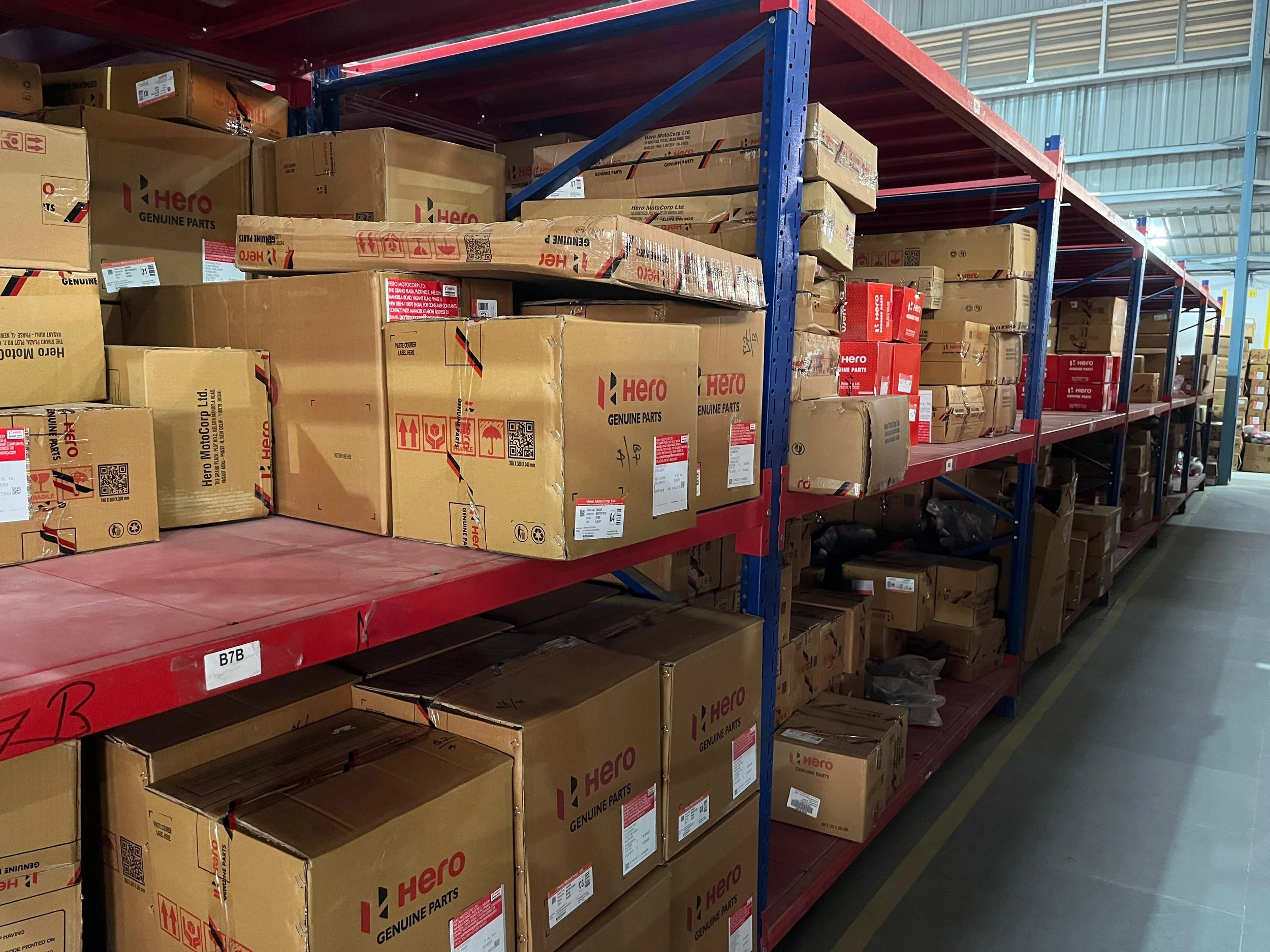 Shelves filled with cardboard boxes labeled Hero Genuine Parts in a warehouse.