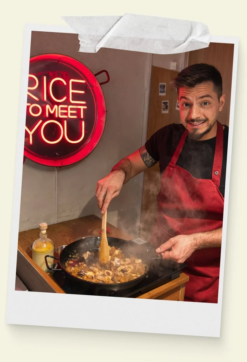 Hombre cocina en el taller de paella de Rice To Meet You en Barcelona