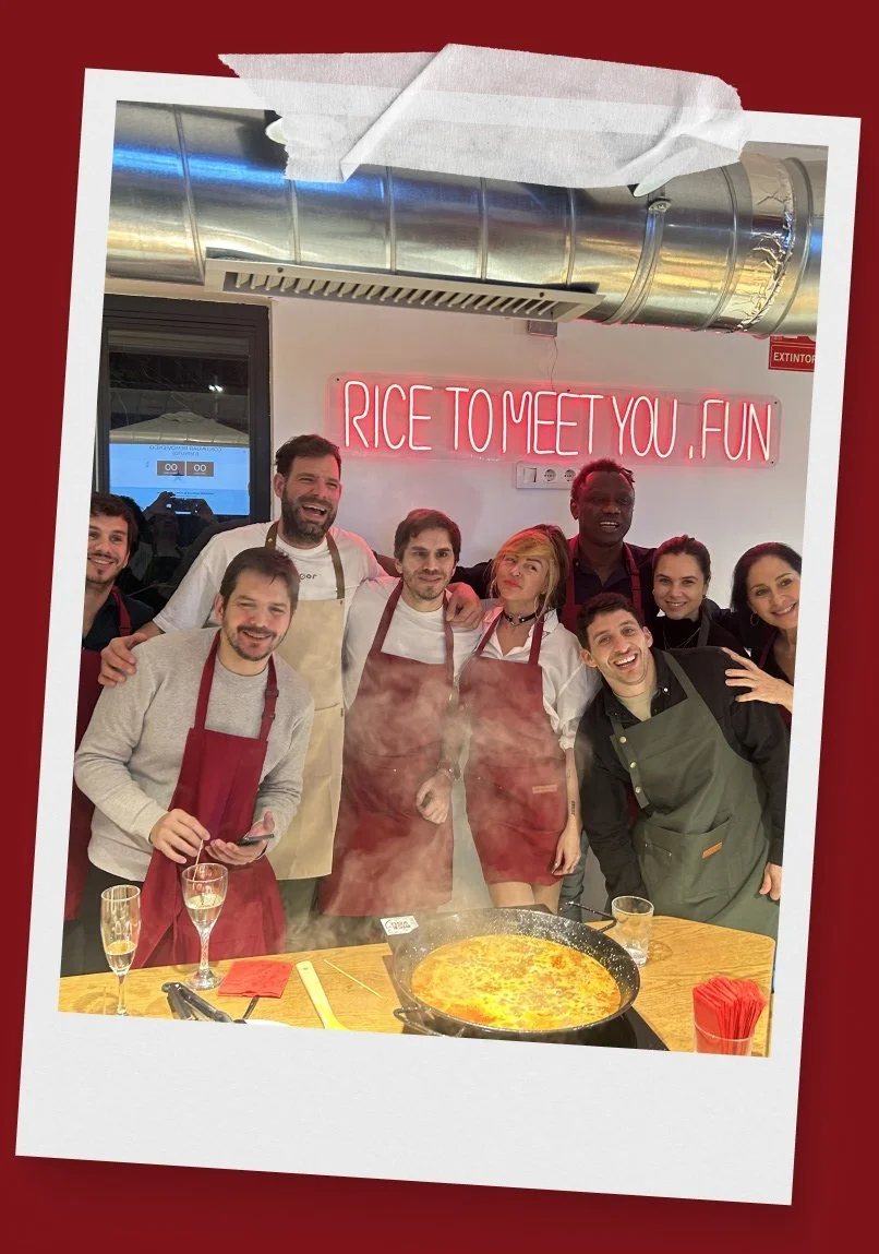 Un grupo de personas felices después de haber cocinado una paella en el taller de Rice To Meet You en Barcelona