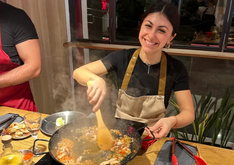Participante cocinando su propia paella durante un taller privado en El Raval, Barcelona