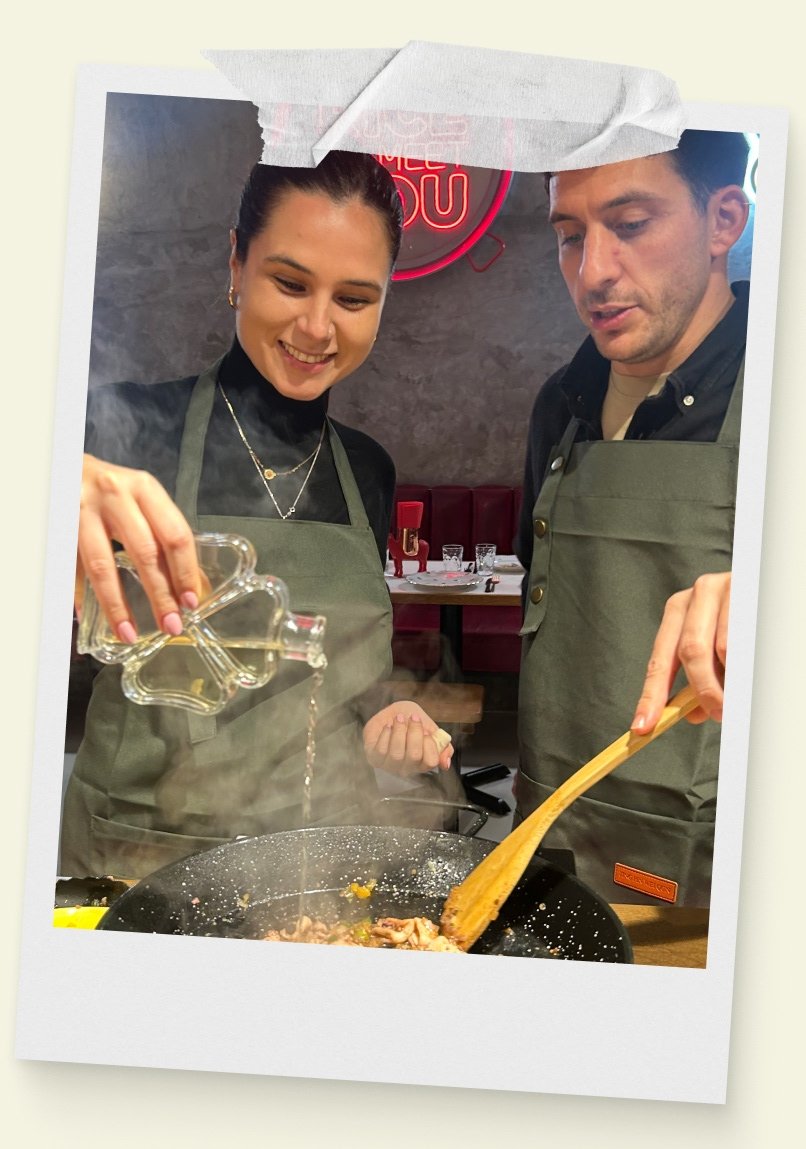 Una pareja cocina en el taller de paella de Rice To Meet You en Barcelona