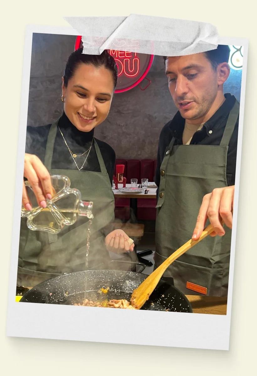 Una pareja cocina una paella en el taller de paella de Rice To Meet You en Barcelona