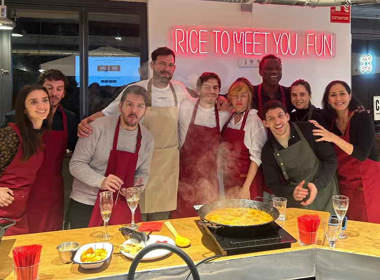 Grupo celebrando con una copa en la mano durante un taller de paella privado en Barcelona