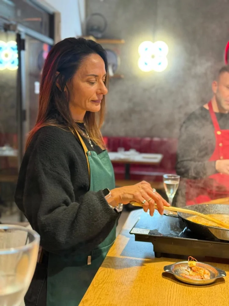 Participante cocinando su propia paella en el taller del Raval, Barcelona