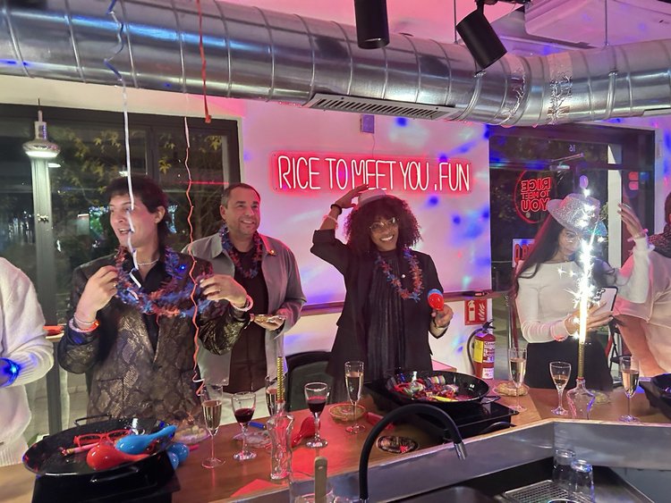 Group celebrating with sparklers and party favors at Rice To Meet You, Barcelona