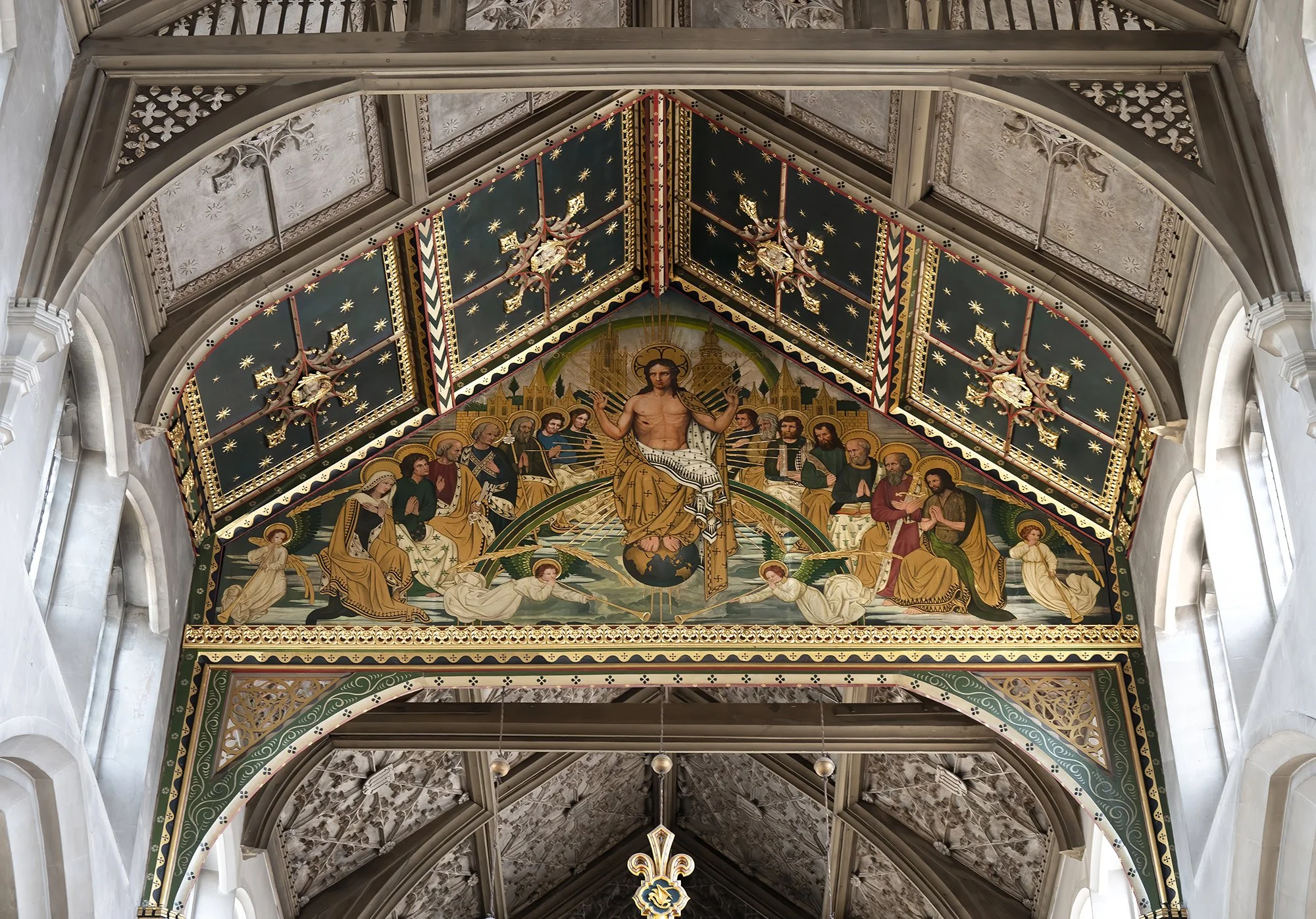 Religious artwork above an archway depicting Jesus Christ as the central figure surrounded by saints and angels, with a decorated ceiling featuring stars.
