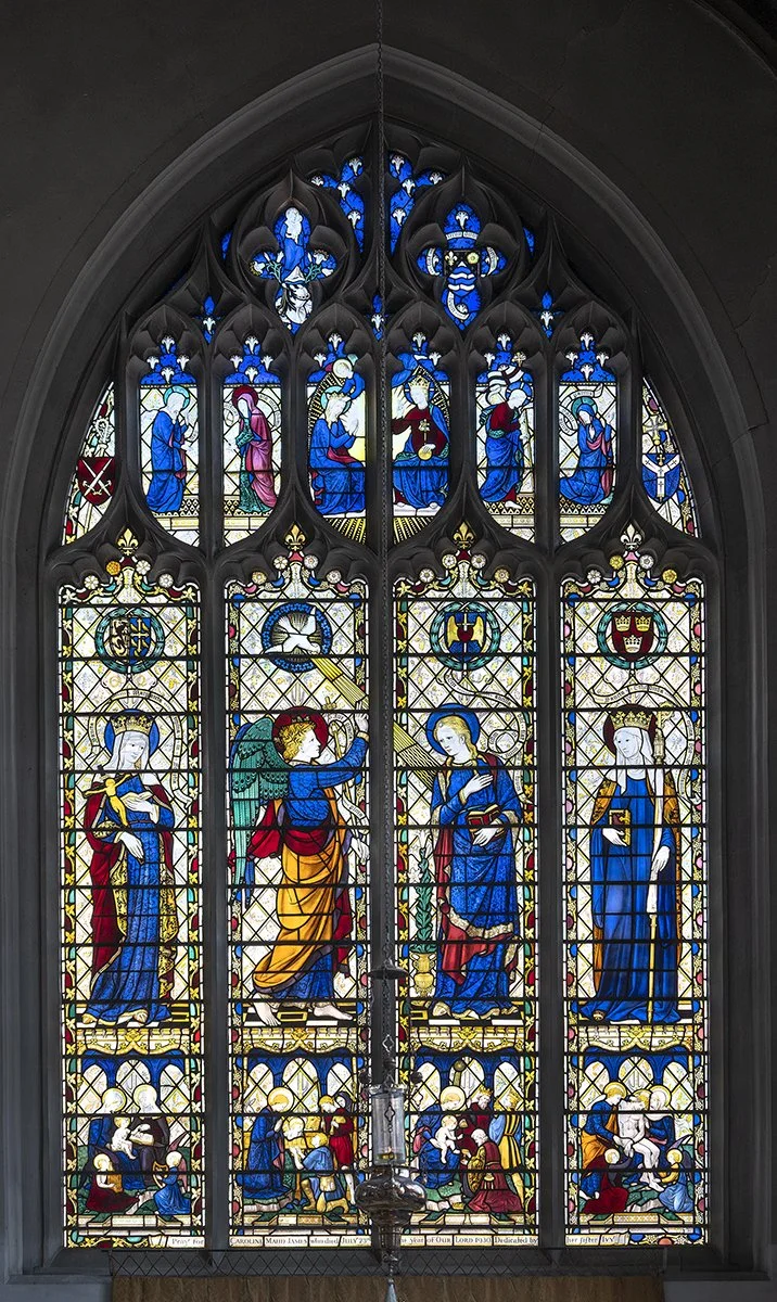 Colorful stained glass window depicting religious scenes and figures.