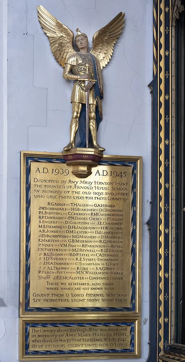 A religious memorial plaque with a golden angel statue above it. The plaque has dates from 1939 to 1945 and a list of names. The top of the plaque is dedicated to Amy Mary Hanson Hunt, who died in 1947, and mentions the altar was decorated in her mem