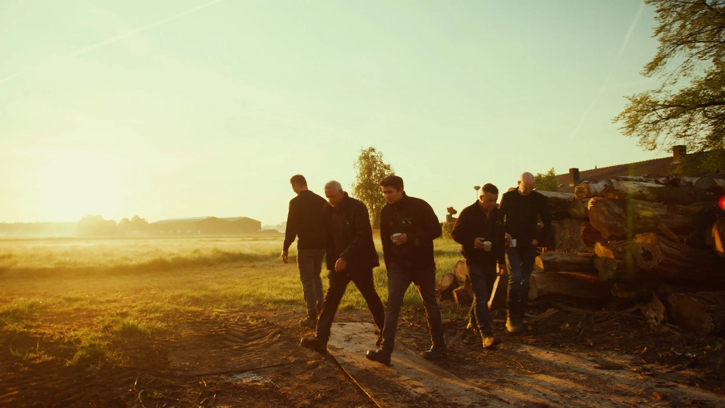 Team van Van Lokven loopt over een terrein tijdens zonsopkomst