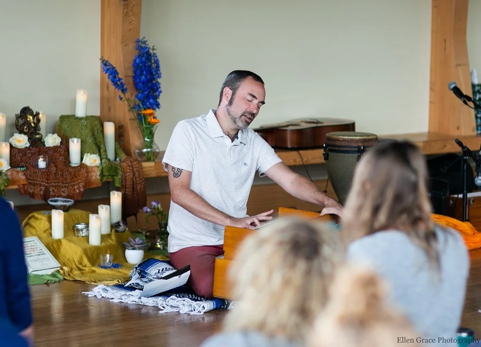 Man in a white shirt playing the harmonium