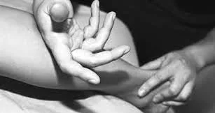 Två händer, en vuxen och ett barn, som pekar och rör vid varandra i en svartvit bild.