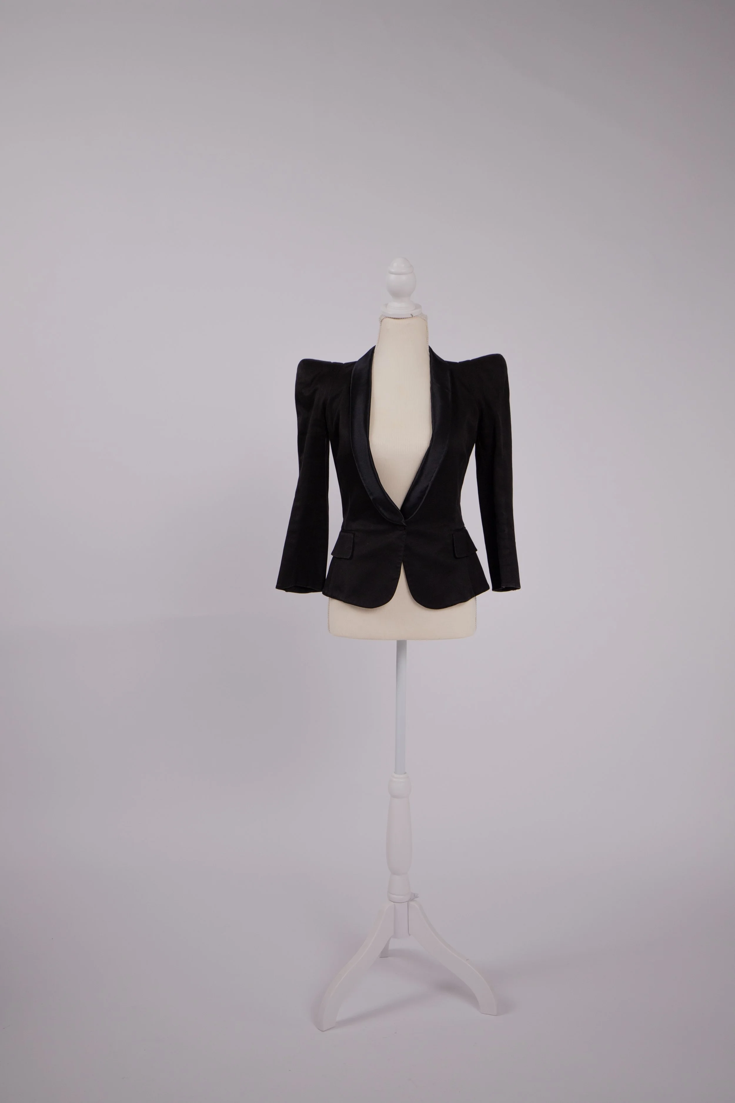 Iconic couture-style blazer on a dress form, reflecting heritage tailoring, architectural shoulders, and high-end fashion craftsmanship.