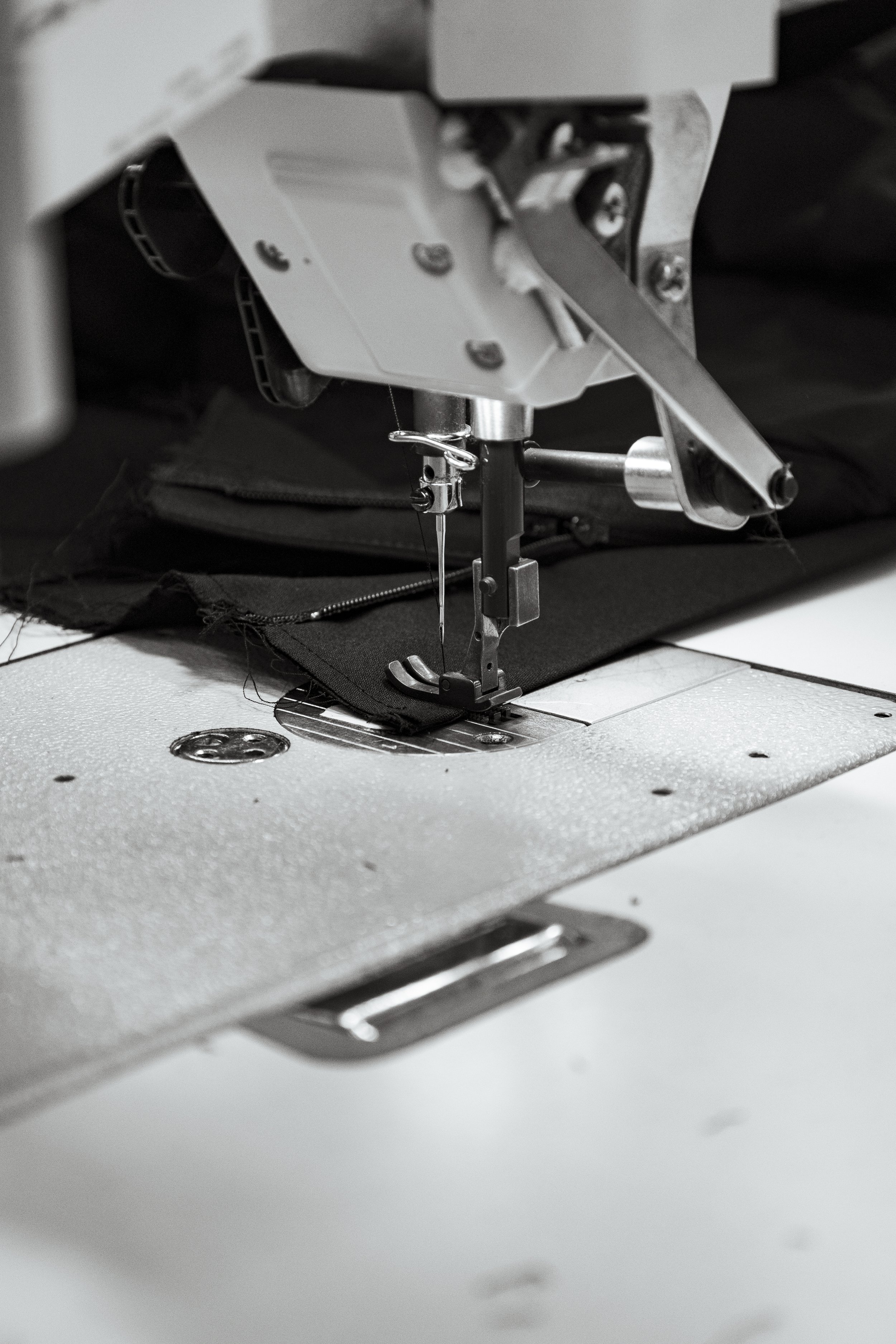 Sewing machine stitching tailored garment detail, highlighting craftsmanship in bespoke womenswear.