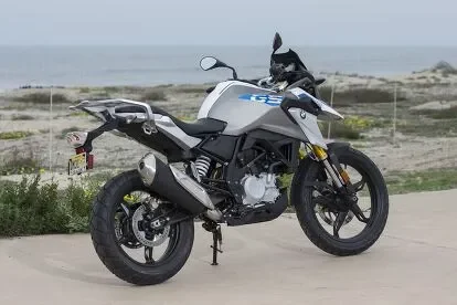 Moto BMW para aluguel em Florianópolis estacionada na praia, ideal para explorar o litoral de Santa Catarina.