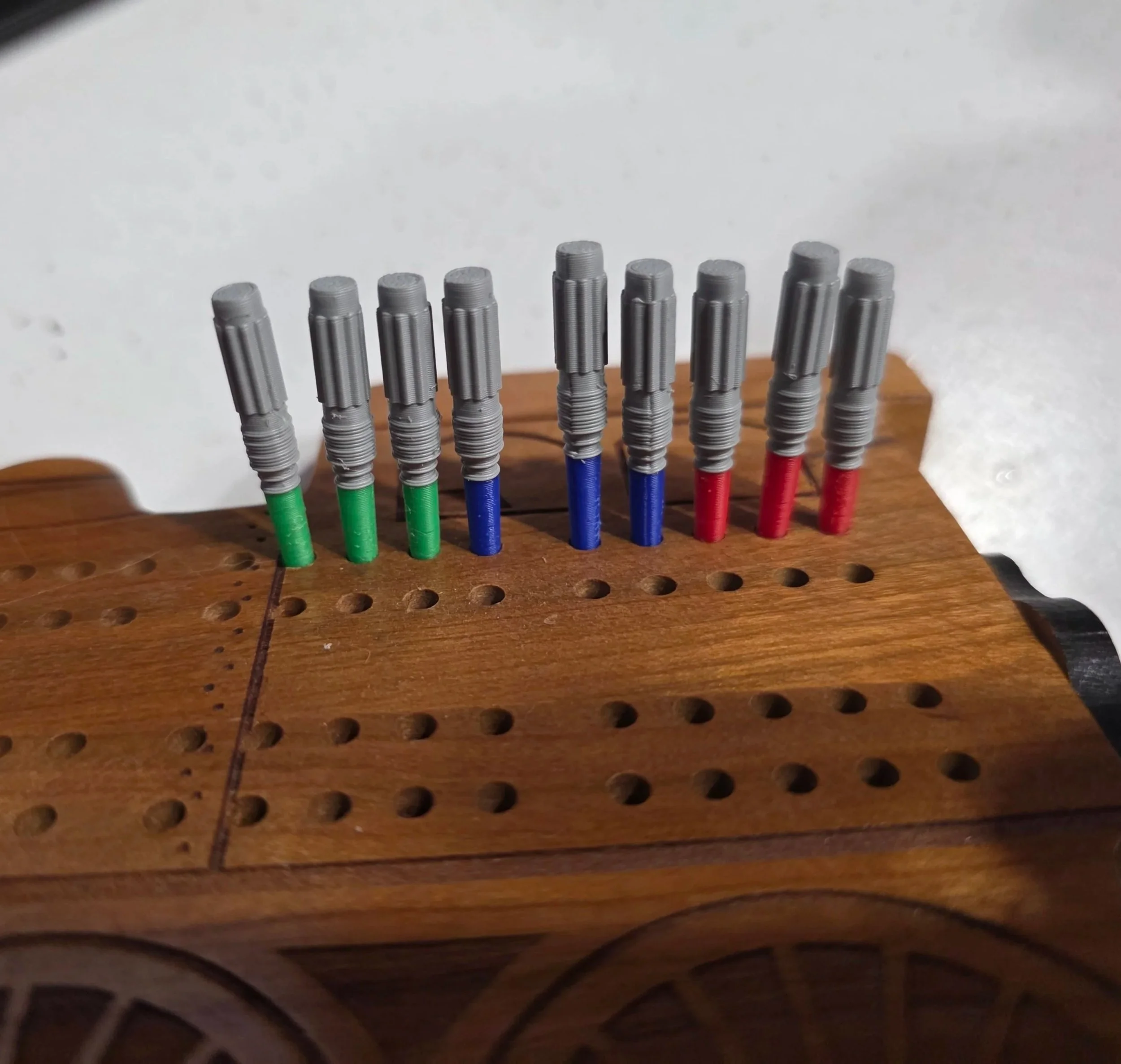Close-up of a wooden board with multiple colorful pens arranged upright.