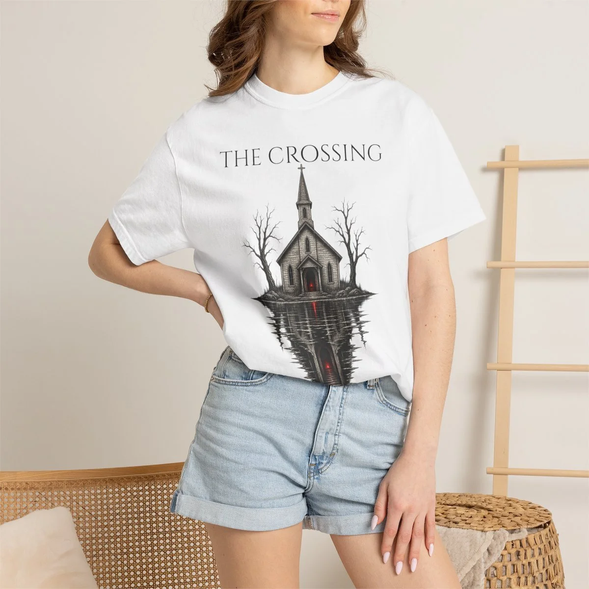 The Crossing Sanctuary graphic tee — White Person 5 Context, modeled in a warm beige room