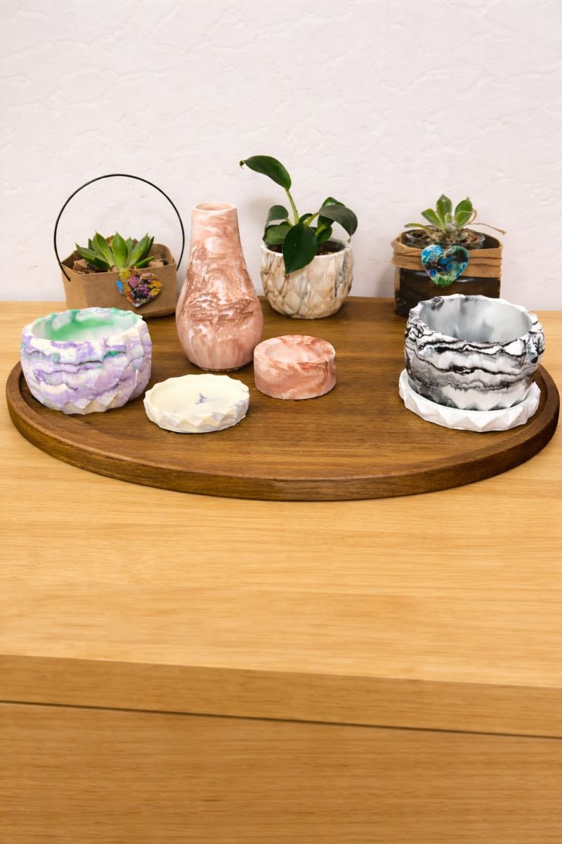 Decorative candles and potted succulents on a wooden tray.