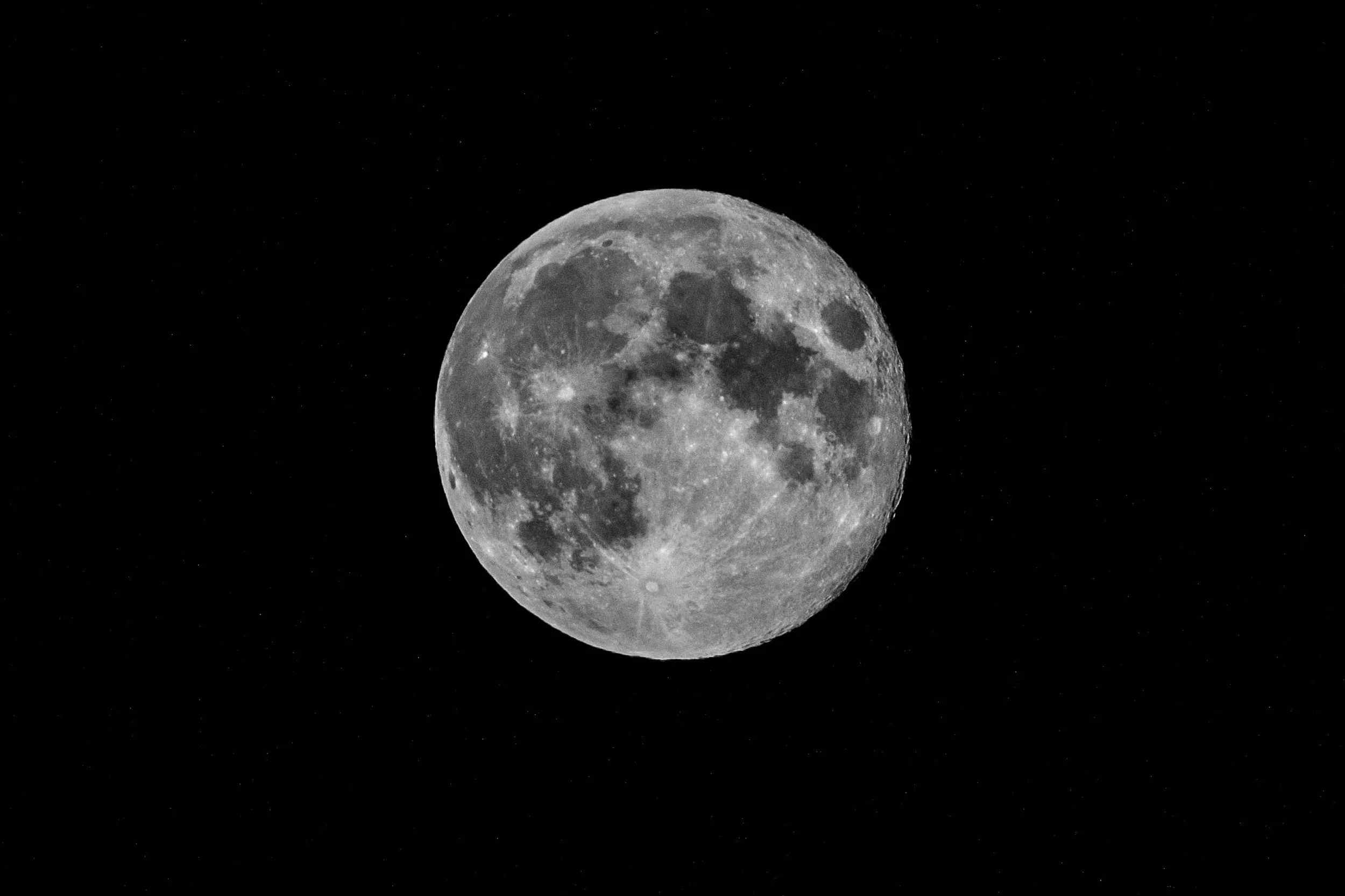 A full moon in a dark sky with visible craters and surface details.