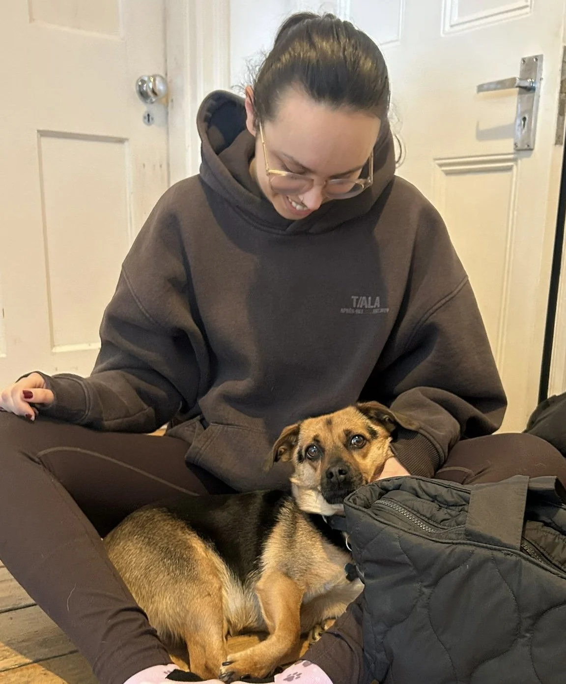 Dog trainer petting client's dog after training session in London