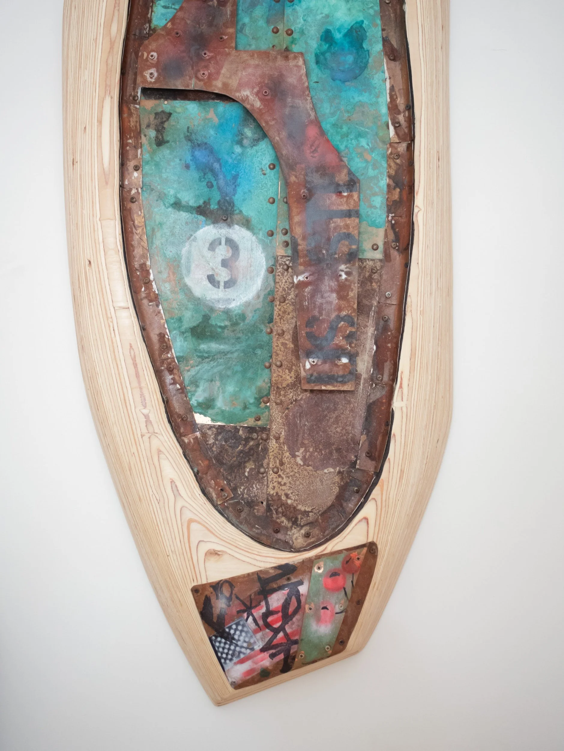 Decorative wooden boat with metal inlaid art featuring abstract colorful shapes, numbers, and text in graffiti style.