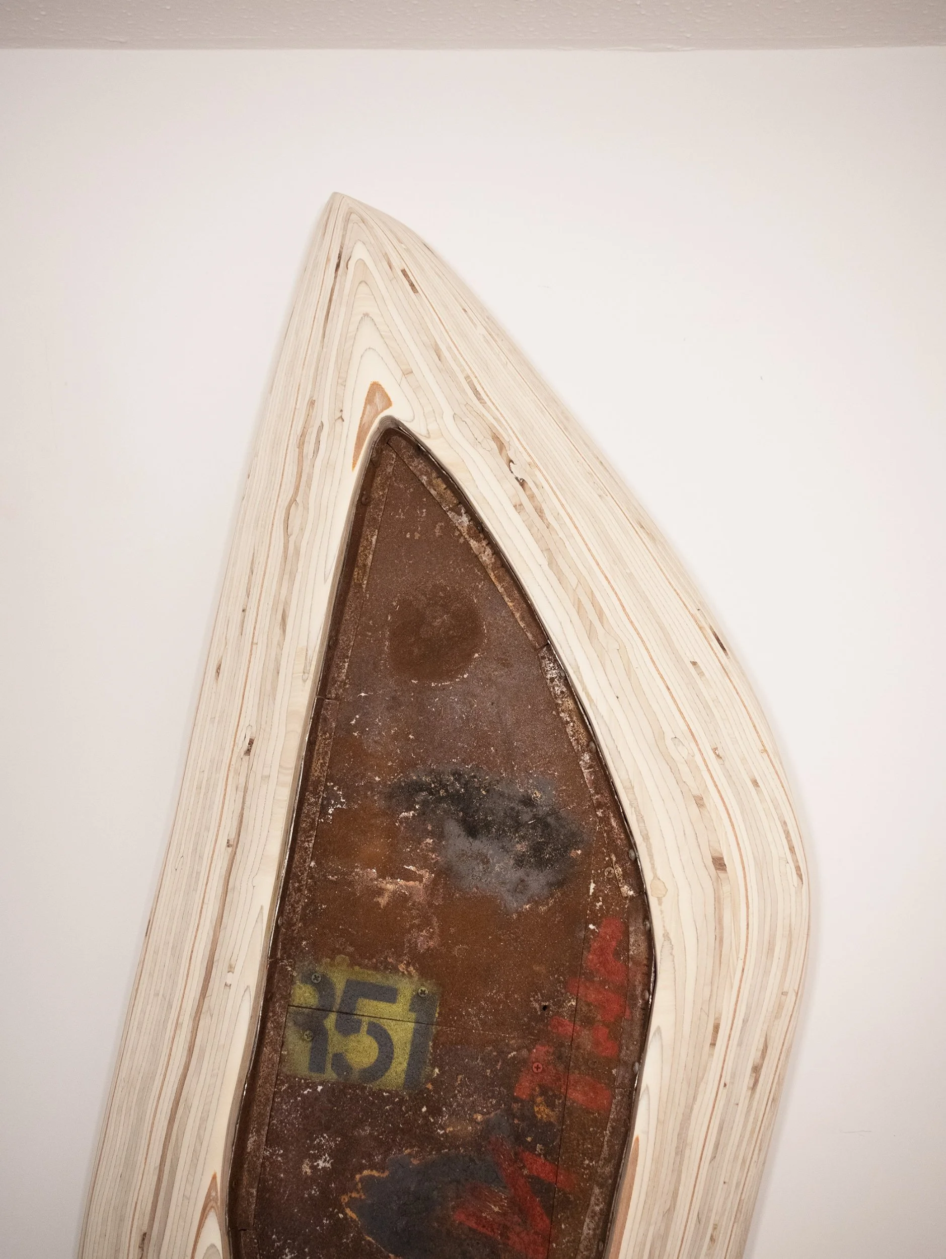 View of a furnace opening with a wooden frame around it, showing the inside of the furnace with some mold or residue and a partially visible number 15 on the floor.