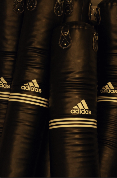Nahaufnahme von schwarzen Adidas Boxsäcken mit weißen Logos und Streifen
