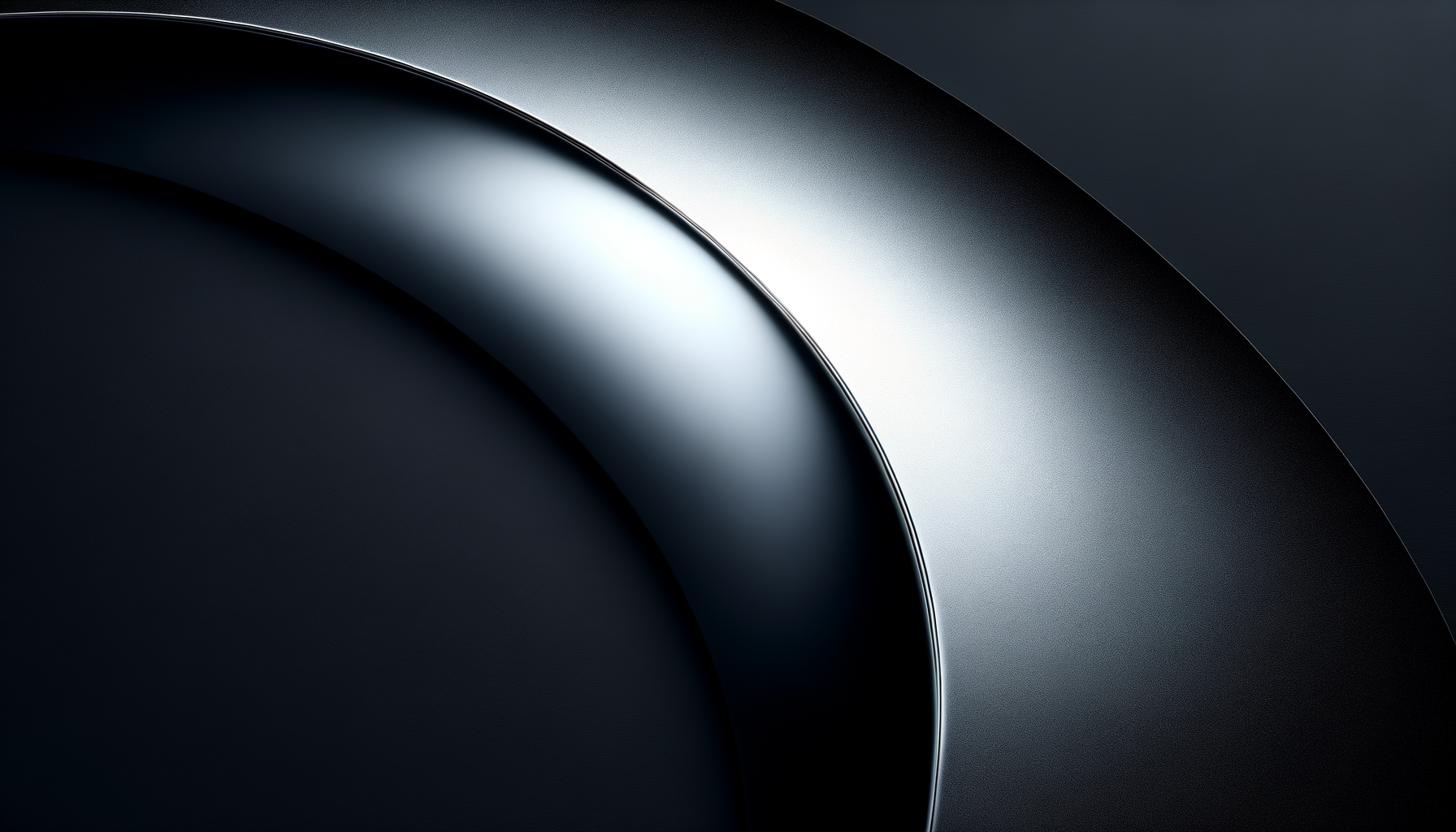 Close-up of a dark metallic or black object with smooth curved surfaces and reflective highlights.