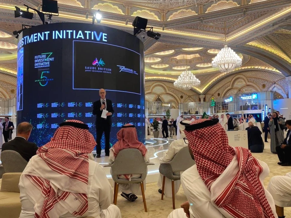 A speaker on stage at a conference in Saudi Arabia