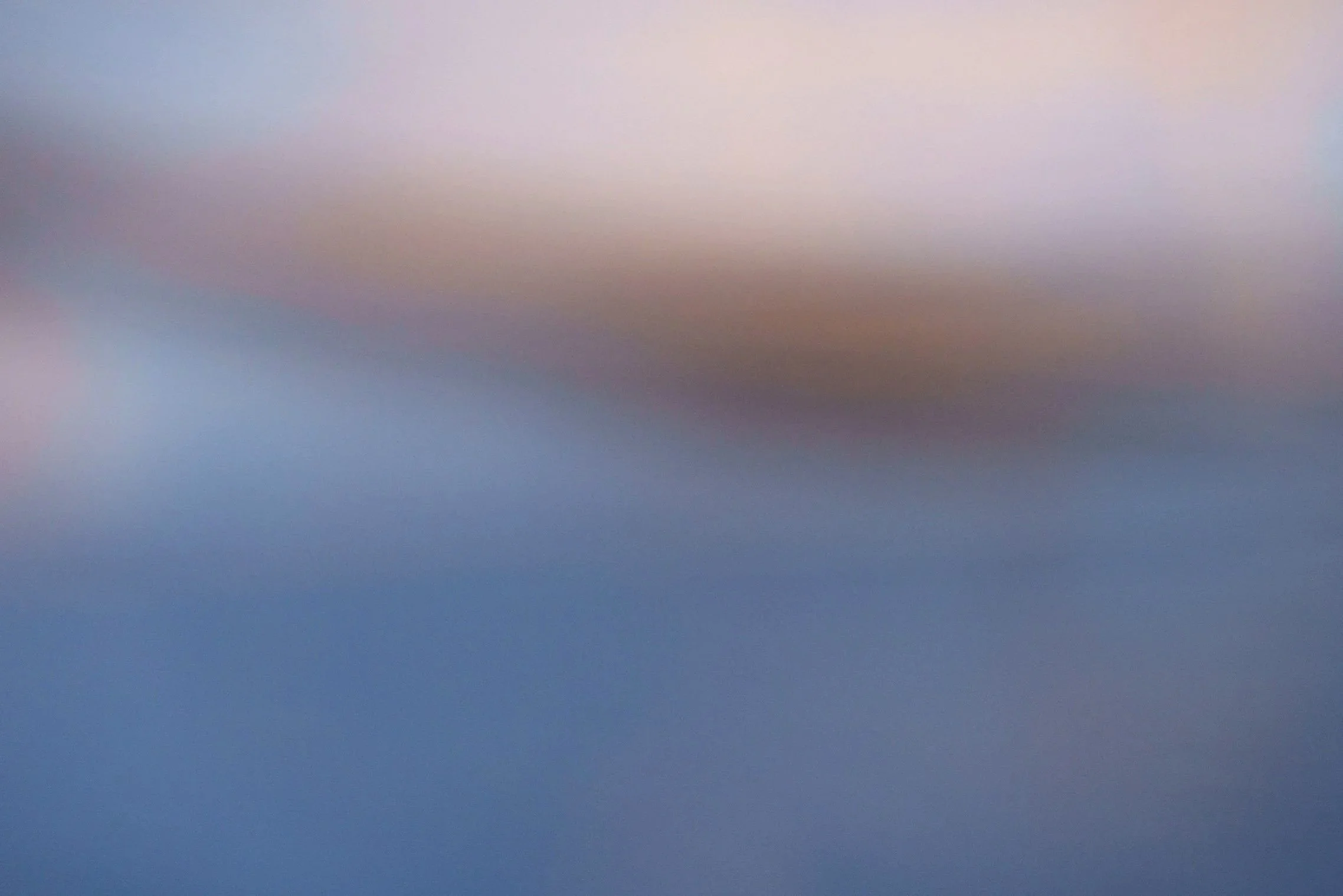 Blurred, gradient-colored abstract background with shades of pink, blue, and purple.