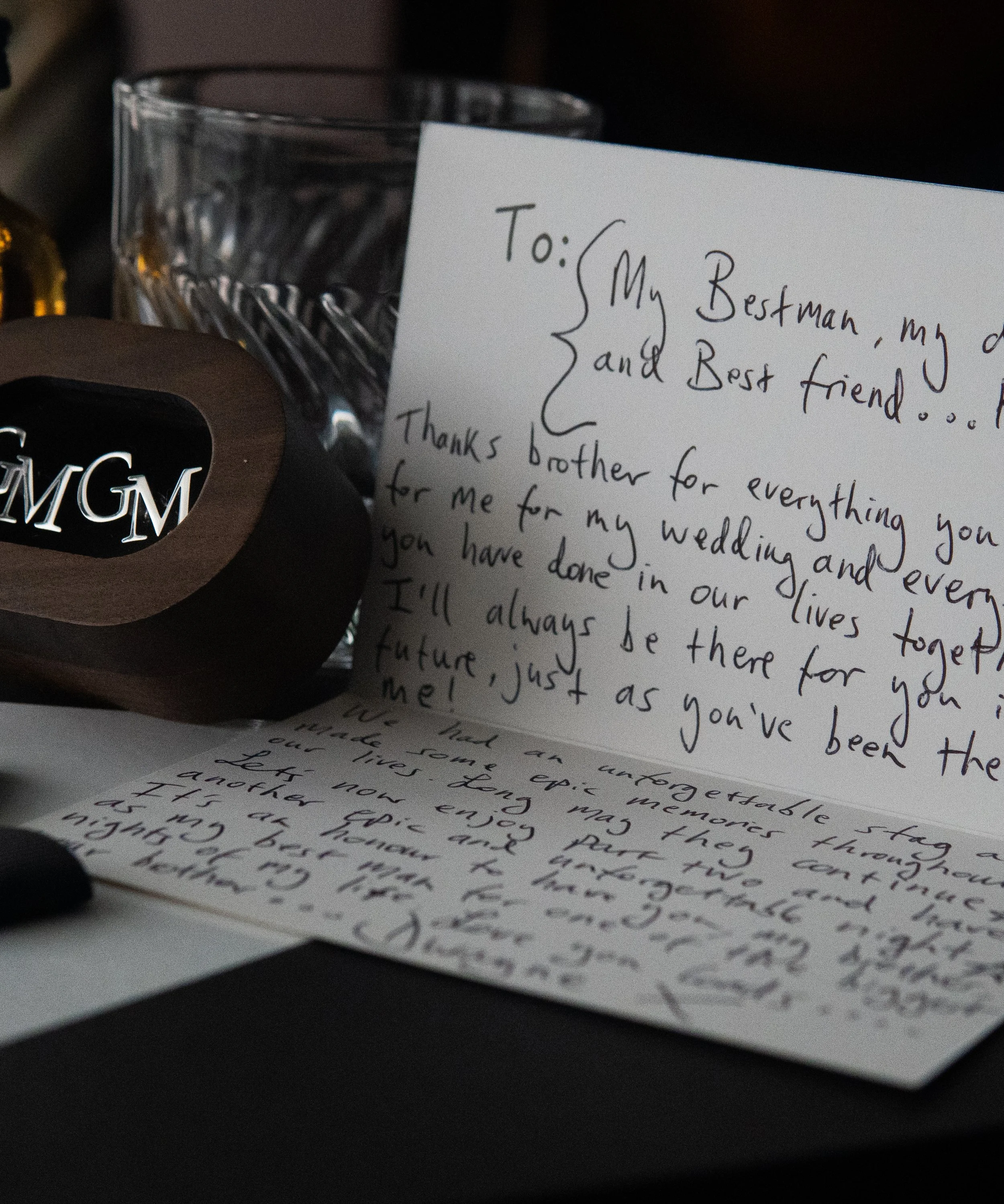 A handwritten thank you letter addressed to a brother and a note card with the MGM logo, a wine glass, and part of a black and white photograph in the background.