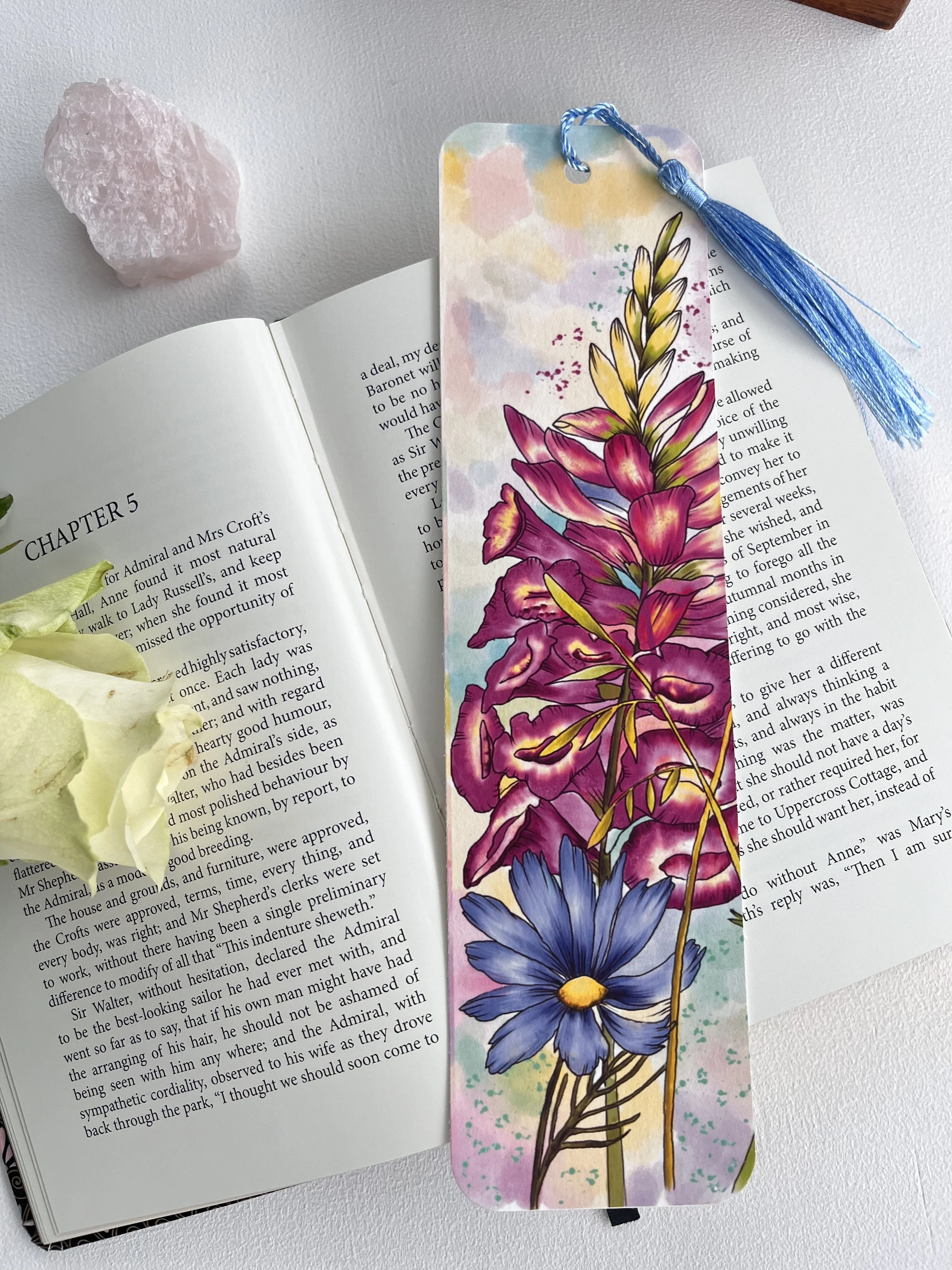 Pink foxglove bookmark with tassel photographed on an open book