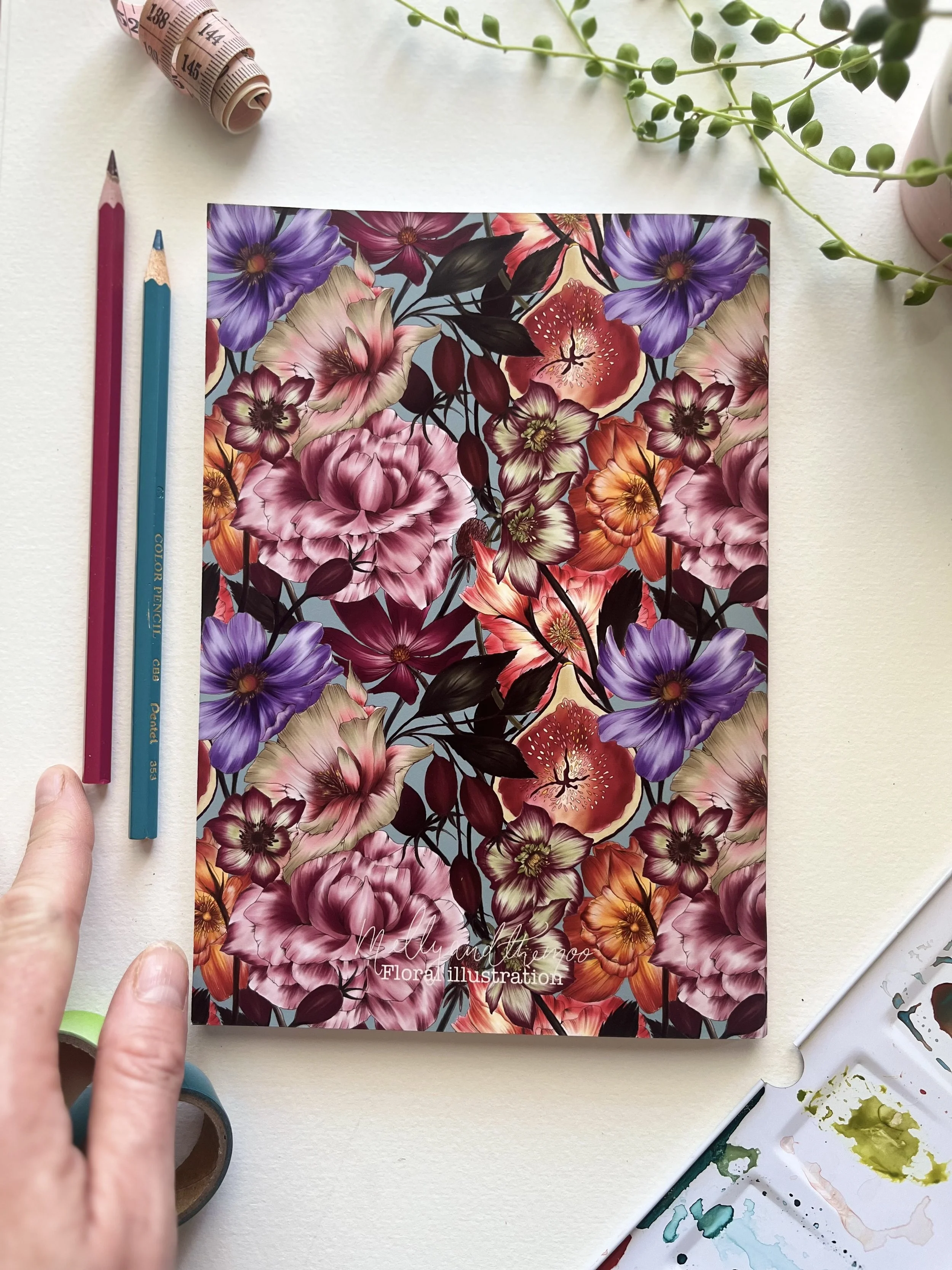 Back view of the notebook with the same floral pattern as the front. Small logo in the bottom centre which reads ‘mellyandthemoo’