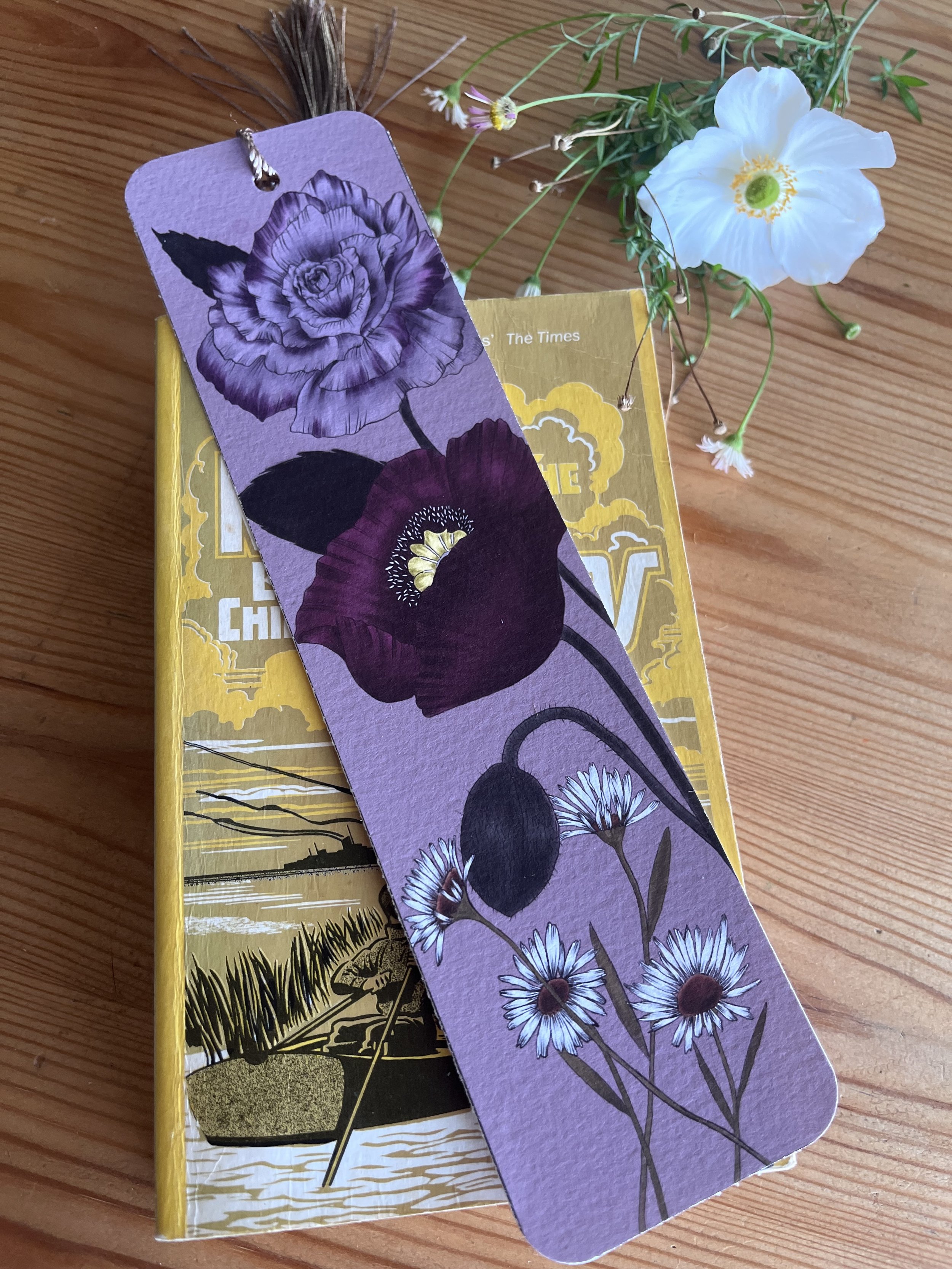 Deep purple bookmark photographed on top of a vintage book.