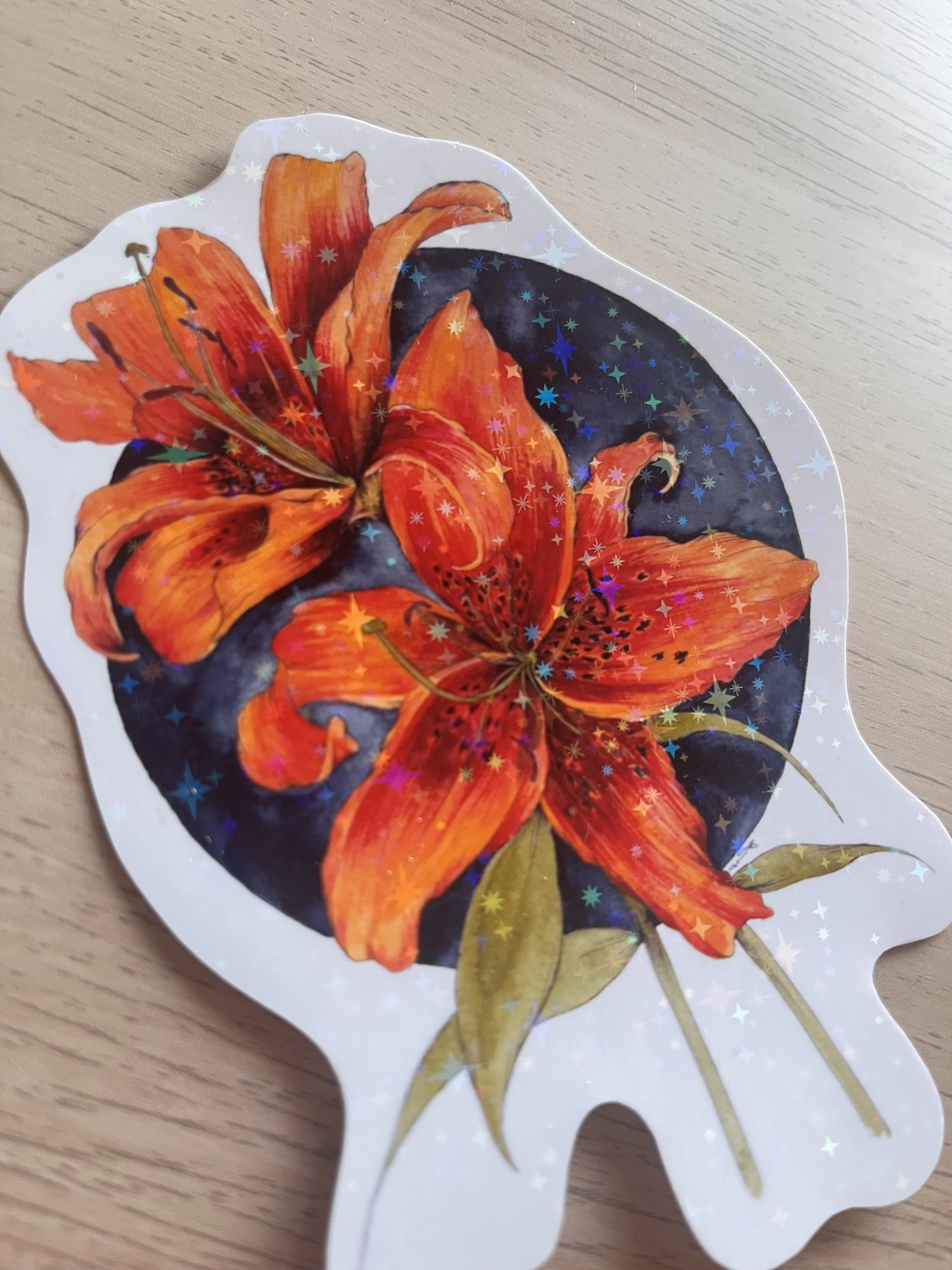 Orange stargazer lily sticker on a wooden desk