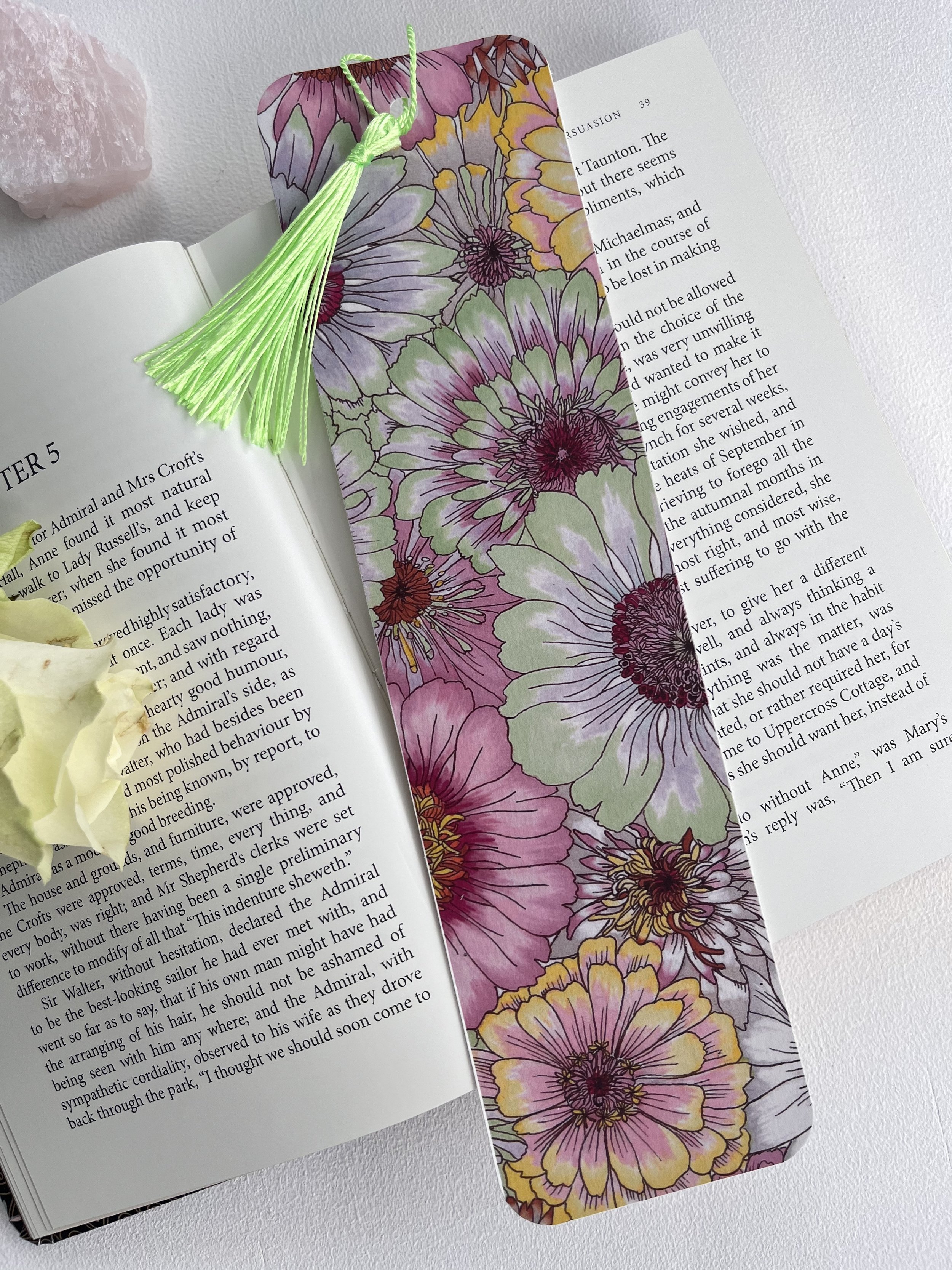 Pastel Daisy bookmark with tassel photographed on an open book with crystals