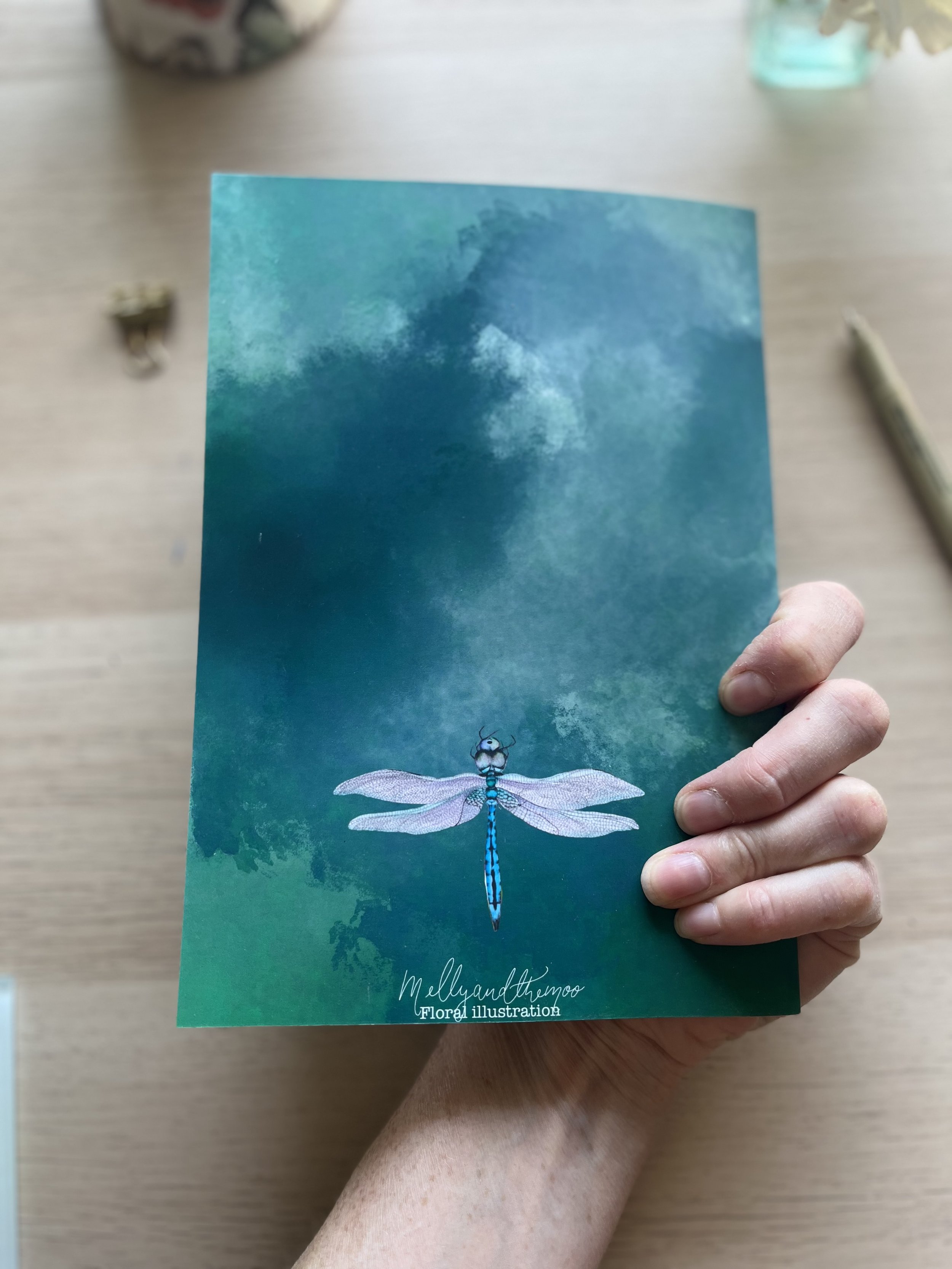 Dragonfly notepad back cover. The back cover has a smaller dragonfly and a logo which reads mellyandthemoo